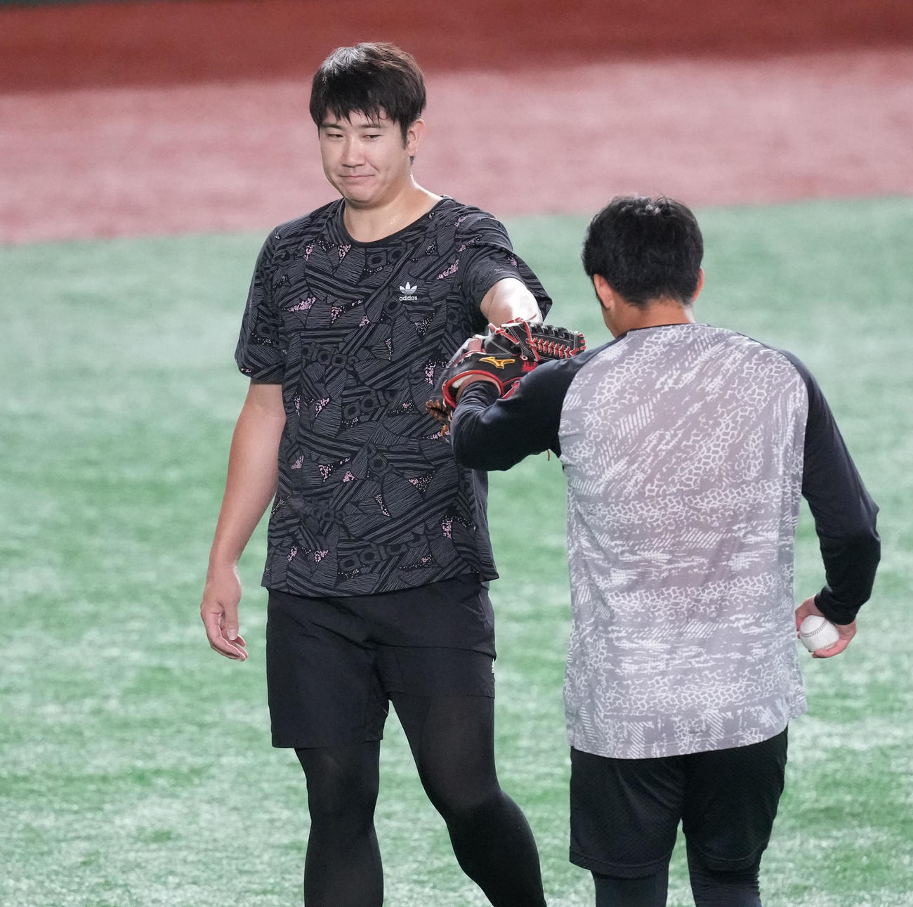 試合前練習のキャッチボールを終え、赤星（右）とタッチを交わす巨人菅野（撮影・鈴木みどり）