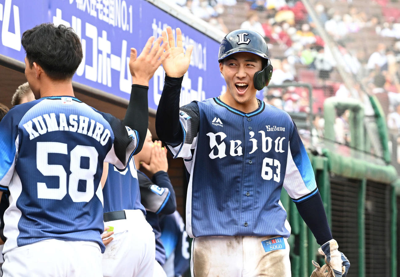 楽天対西武　8回表西武2死一、二塁、源田の2点適時三塁打から生還した一走長谷川（右）はチームメートとタッチを交わす（撮影・滝沢徹郎）