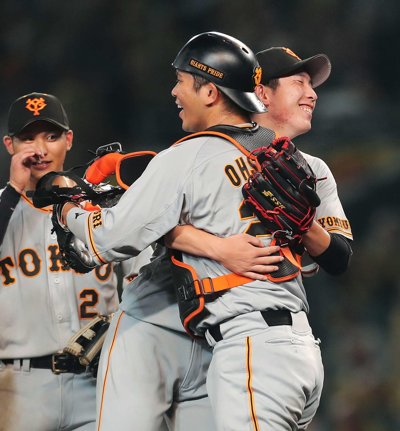 阪神対巨人　プロ初完封勝利を挙げた戸郷（中央）は大城と抱き合い喜ぶ（撮影・河田真司）