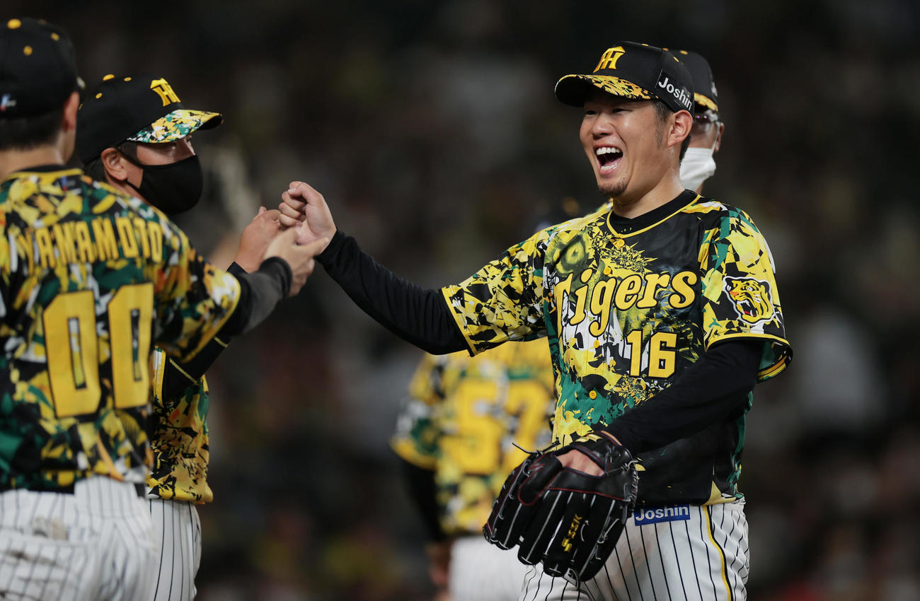 阪神対巨人　5回表の巨人打線を抑え、笑顔を見せながらベンチへ戻る阪神西勇（右）（撮影・前田充）