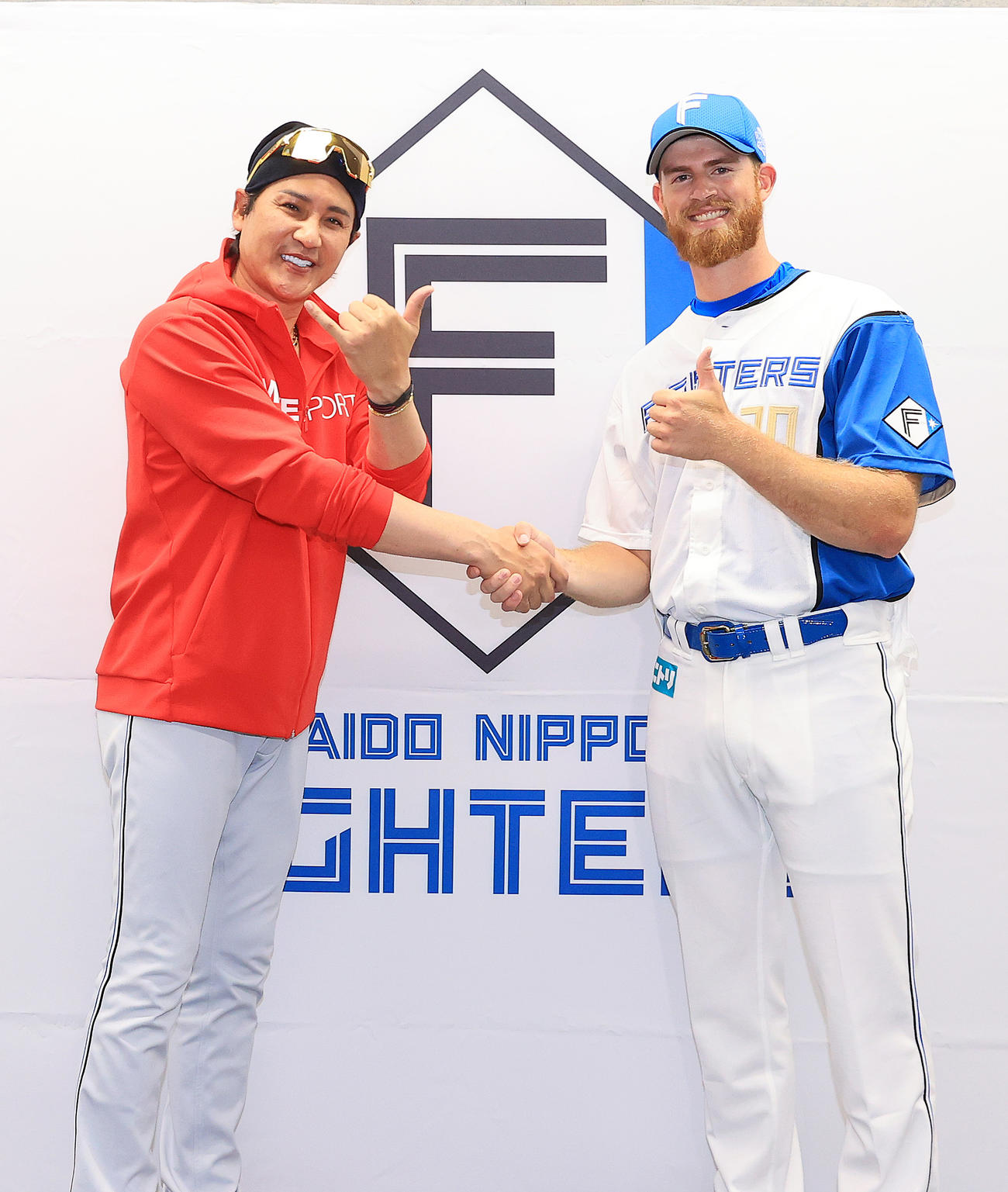 笑顔で握手を交わす日本ハム新庄監督（左）とメネズ