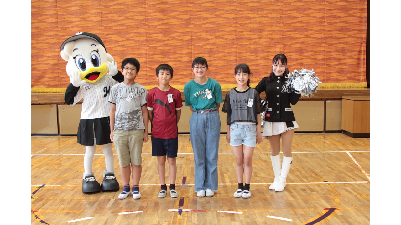 流山市立東小学校での寄贈式に参加した代表児童たちと、ロッテのマスコットのリーンちゃん（左）、公式チアパフォーマーM☆Splash！！のYUKI（右）（ロッテ球団提供）