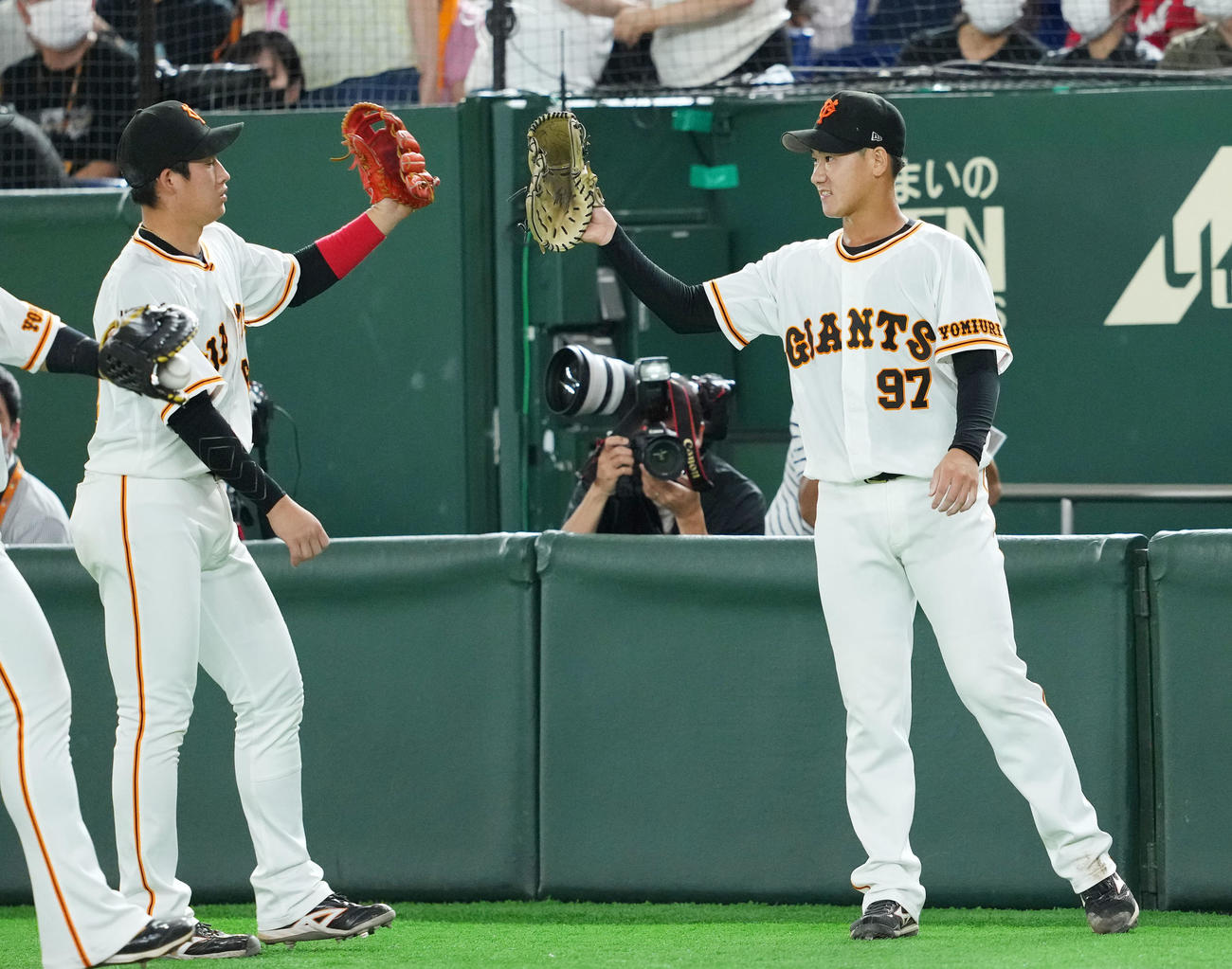 巨人対広島　7回表を無失点に抑えナインとタッチを交わす巨人井上（右）（撮影・横山健太）