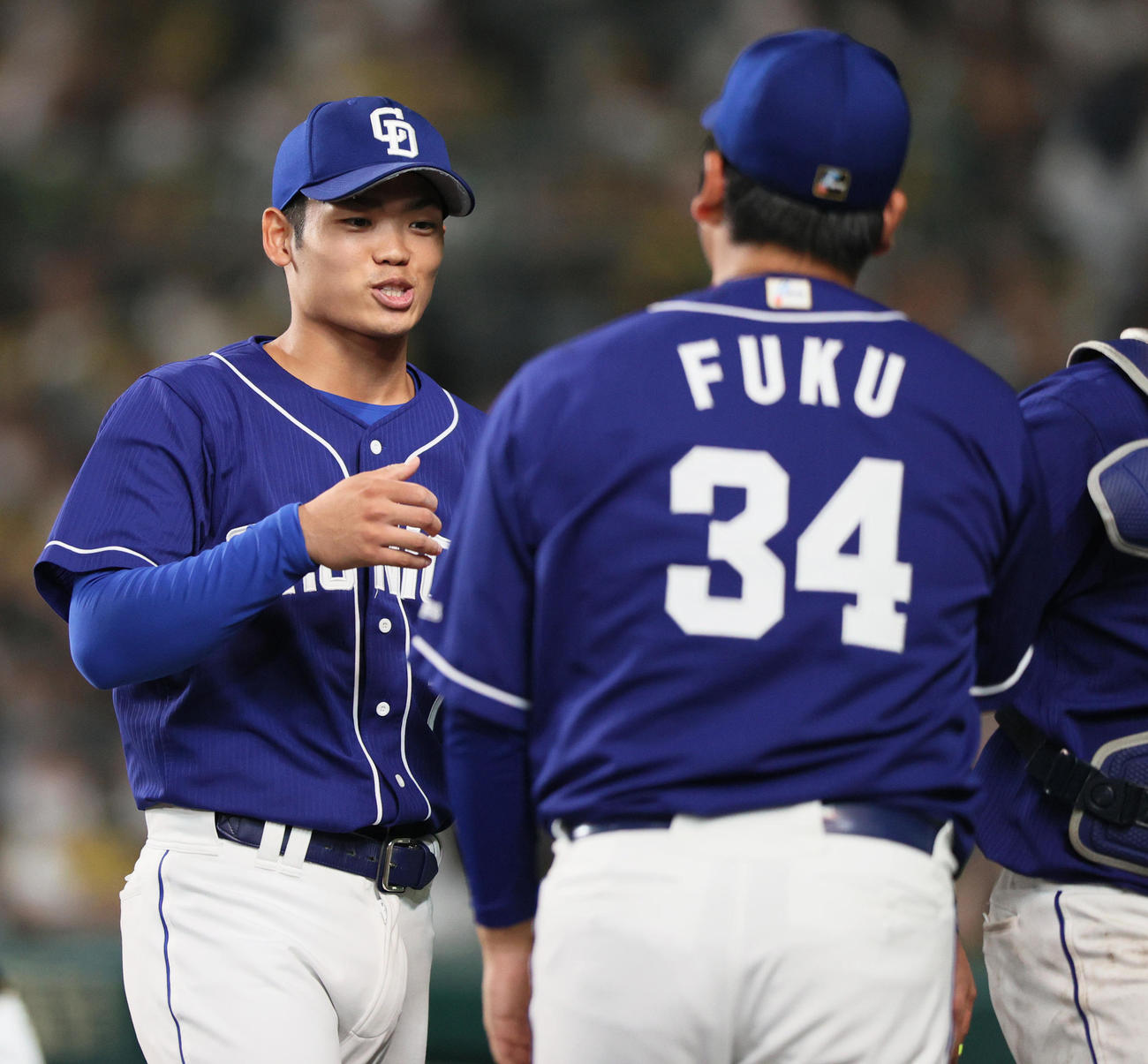 阪神対中日　8回裏阪神2死一塁、福（手前）から継投し無失点に抑え笑顔を見せる根尾（撮影・上山淳一）