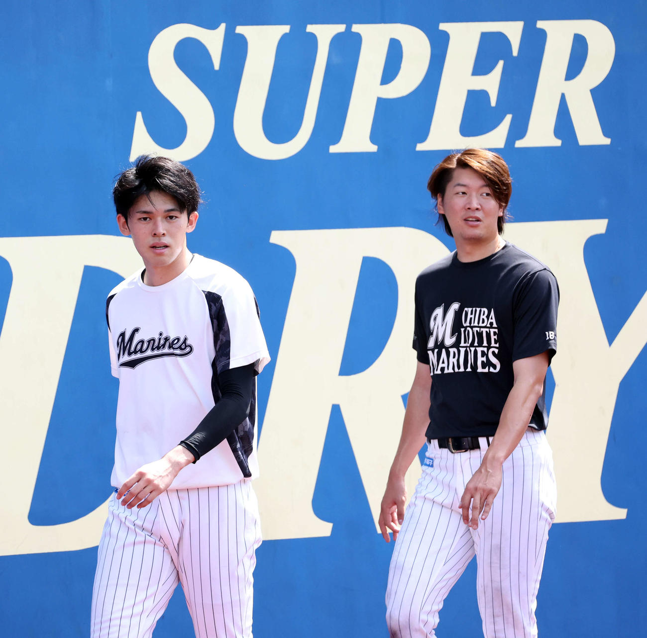 ロッテ対ソフトバンク　インターバルトレーニングで「SUPER」の看板の前を歩くロッテ佐々木朗（左）と二木（撮影・浅見桂子）