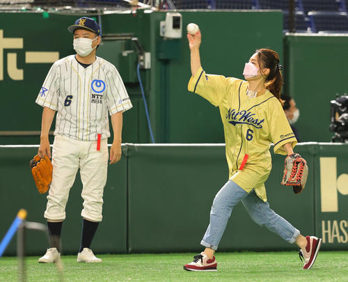 NTT西日本対JR東日本東北　NTT西日本の元遊撃手で、2年前に亡くなった中井諒さんの母啓子さん（右）が始球式を行い、父康浩さん（左）が遊撃の位置に入った（撮影・野上伸悟）