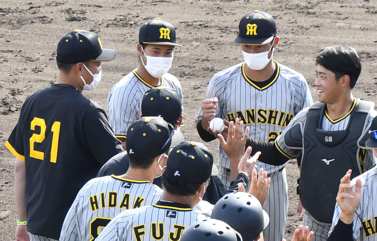 ウエスタン・リーグ、オリックス対阪神　オリックスに勝利し、勝利球を秋山（左）に渡そうとする阪神中川（撮影・中野椋）