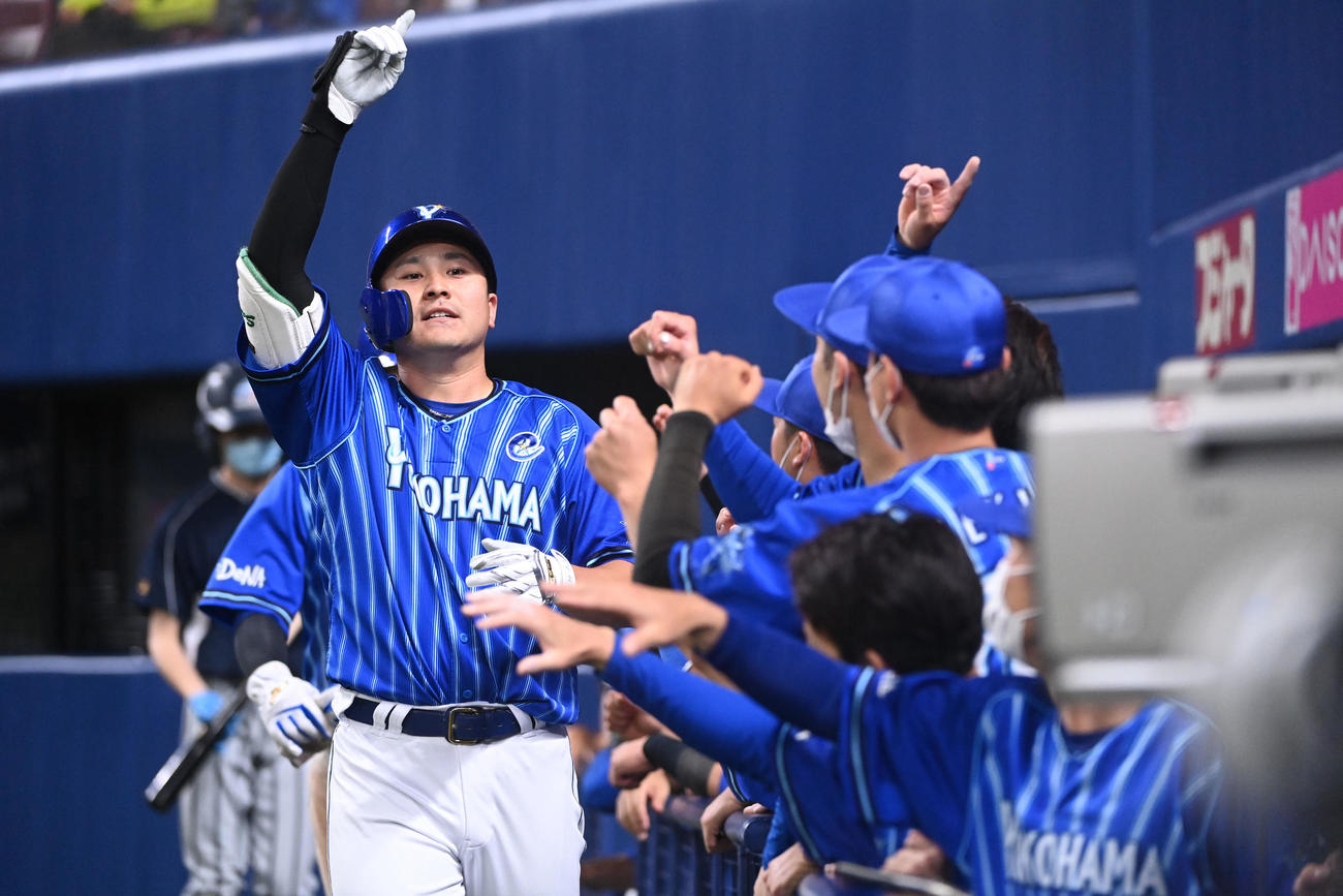 中日対DeNA 5回表DeNA無死一塁、右中間スタンドへ2点本塁打を放ちナインとタッチを交わす佐野（左）（撮影・森本幸一）