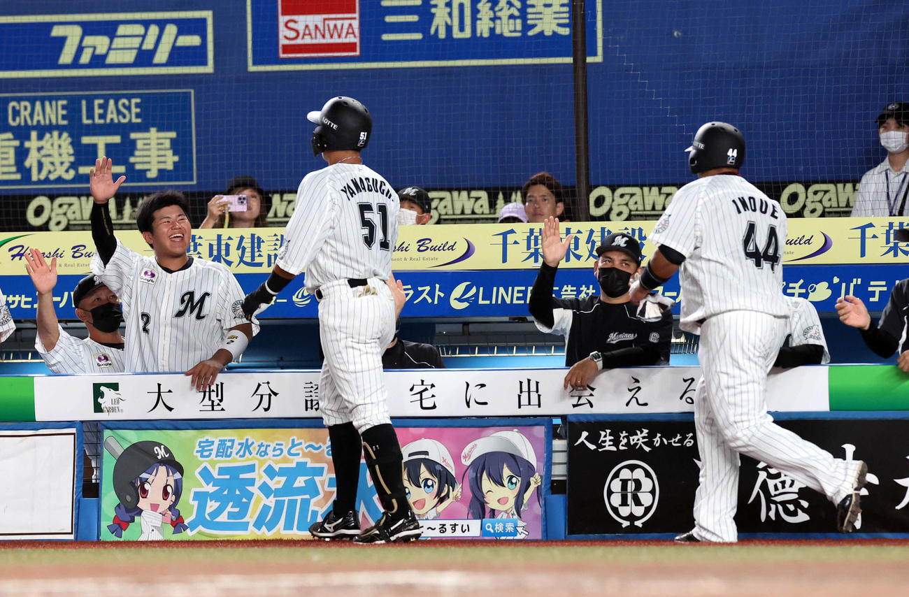 ロッテ対西武　7回裏ロッテ1死一塁、山口（手前左）が左越え2点本塁打を放ち、笑顔のハイタッチで迎える松川（左）、井口監督（右から2人目）らロッテベンチ（撮影・浅見桂子）