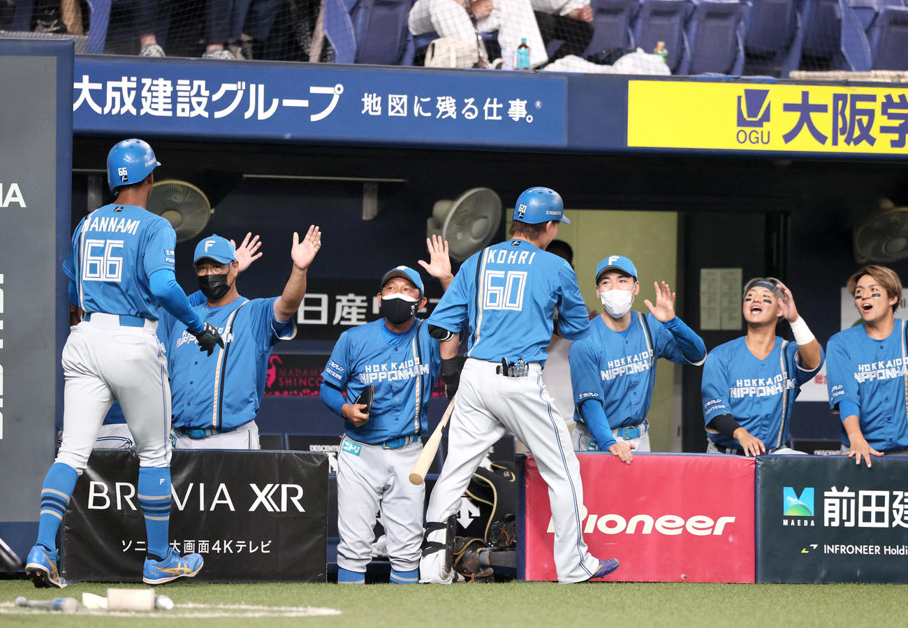 オリックス対日本ハム　4回裏日本ハム1死一塁、木田監督代行（左から2人目）は先制の左越え2点本塁打を放った郡（手前右）と万波（手前左）を出迎える（撮影・上山淳一）