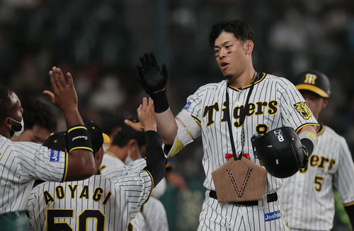 阪神対DeNA 6回裏阪神2死二塁、中越え2点本塁打を放ち、ナインに迎えられる佐藤輝(撮影・前田充