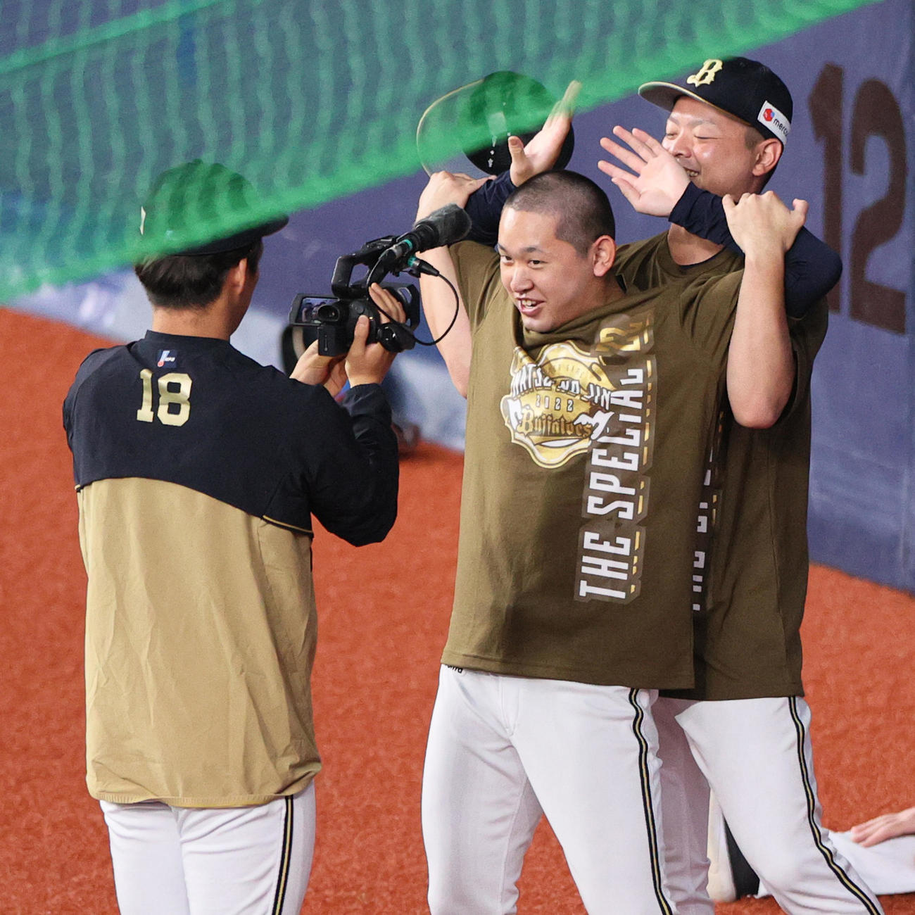 試合前の練習中にオリックス宮城（中央）は黒木（右）に帽子を取られ丸刈り姿をカメラマン山本に激写される（撮影・上山淳一）