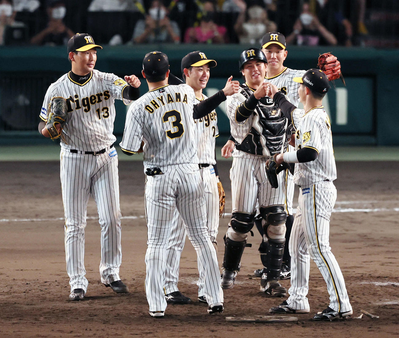 阪神対DeNA　最後を締めた岩崎（左）は笑顔でナインとタッチ（撮影・加藤哉）