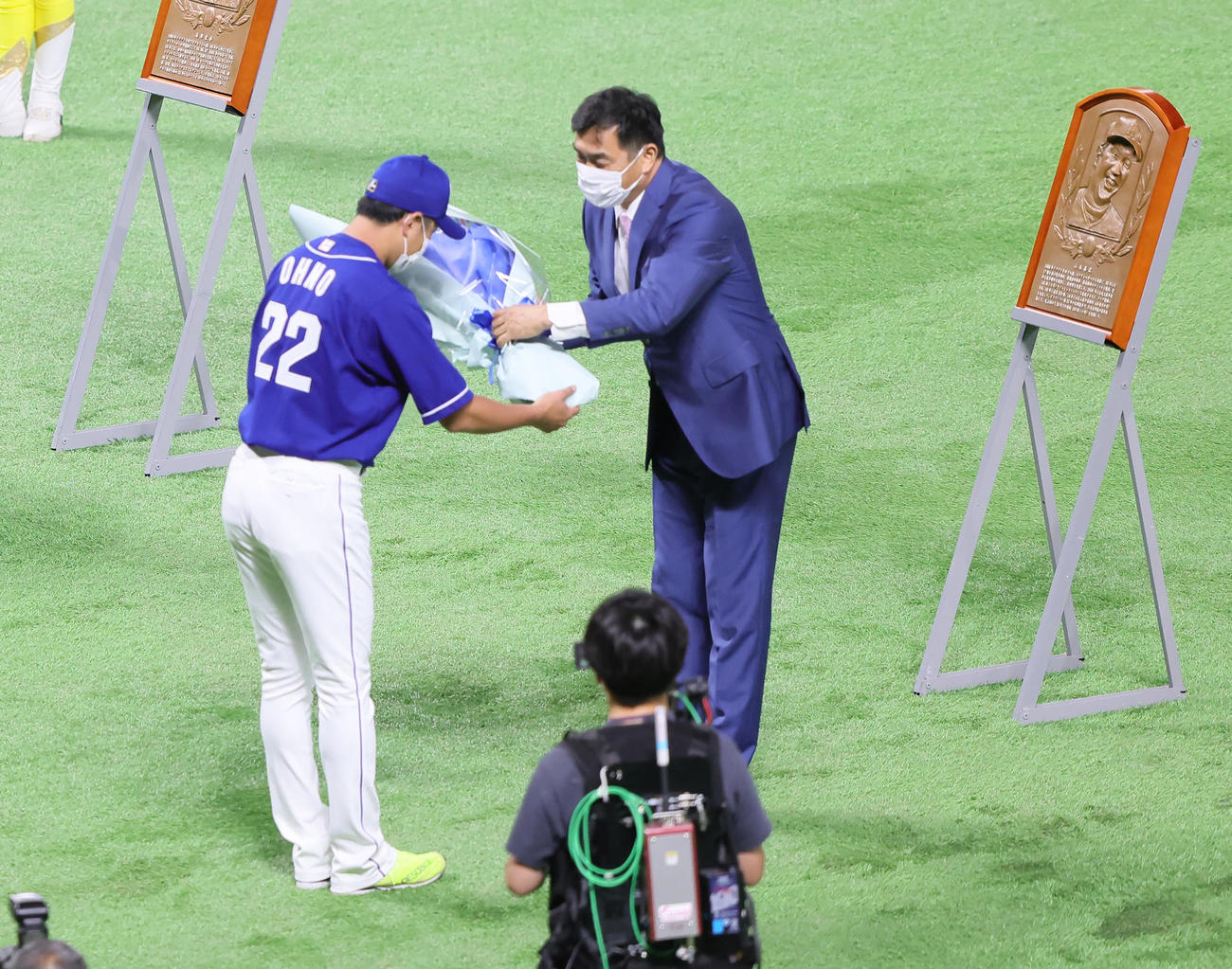 野球殿堂入り表彰を受けた山本氏（右）は中日大野雄から花束を受け取る（撮影・足立雅史）