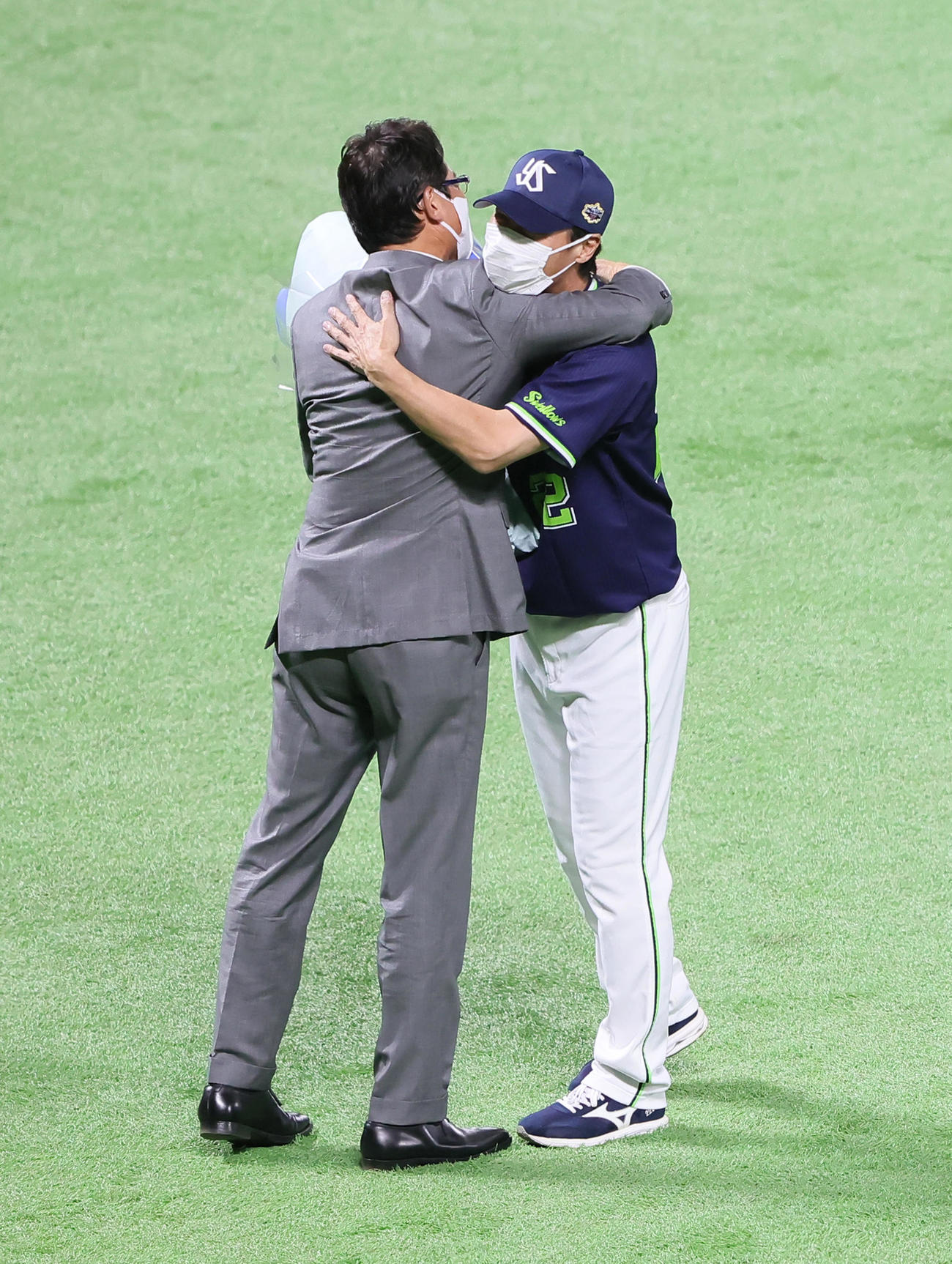 野球殿堂入り表彰を受けたヤクルト高津監督（右）は古田氏から花束を受け取り抱き合う（撮影・足立雅史）