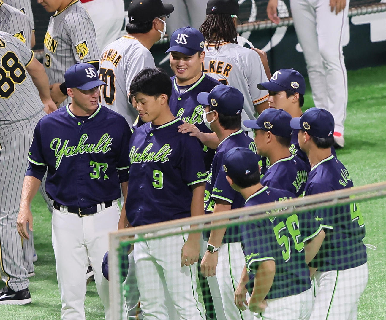 試合前、ヤクルト塩見（前方左から2人目）の肩に手を置き笑顔を見せる村上（後方左）（撮影・足立雅史）