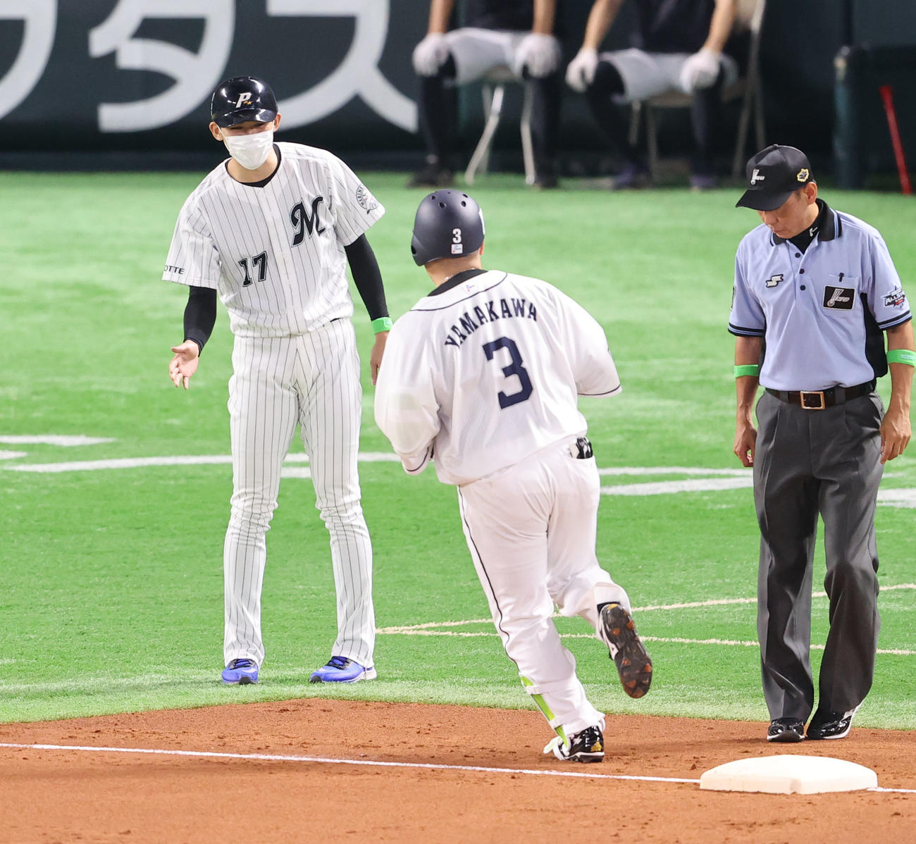全パ対全セ　2回裏全パ無死、三塁コーチの佐々木朗（左）はソロ本塁打を放った山川（中央）とタッチを交わす（撮影・梅根麻紀）