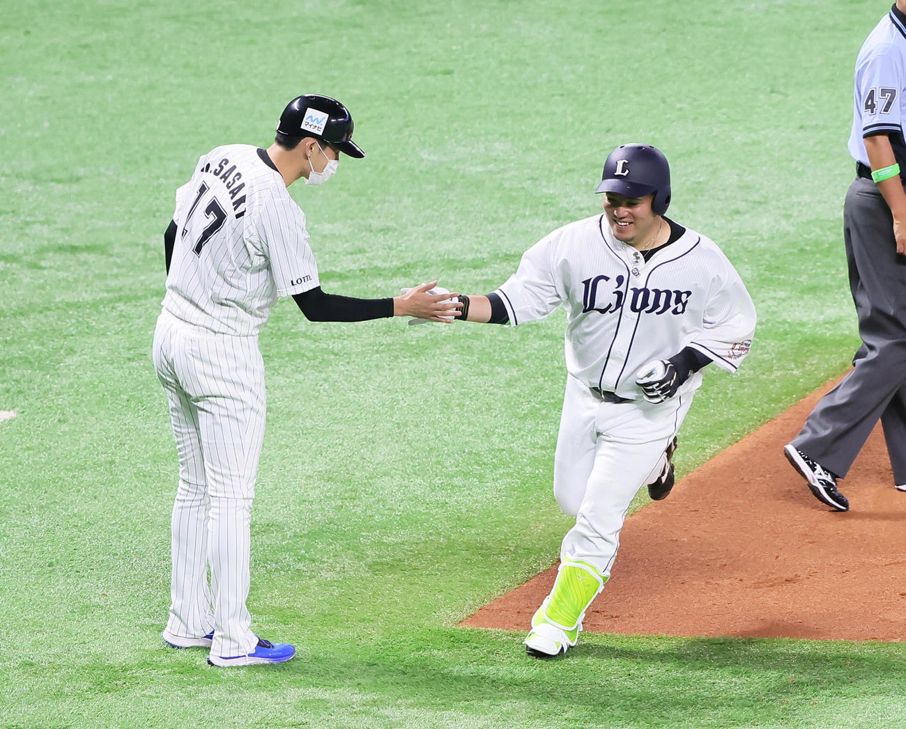 全パ対全セ　2回裏全パ無死、山川（右）は本塁打を放ち三塁コーチを務めた佐々木朗とタッチを交わす（撮影・足立雅史）