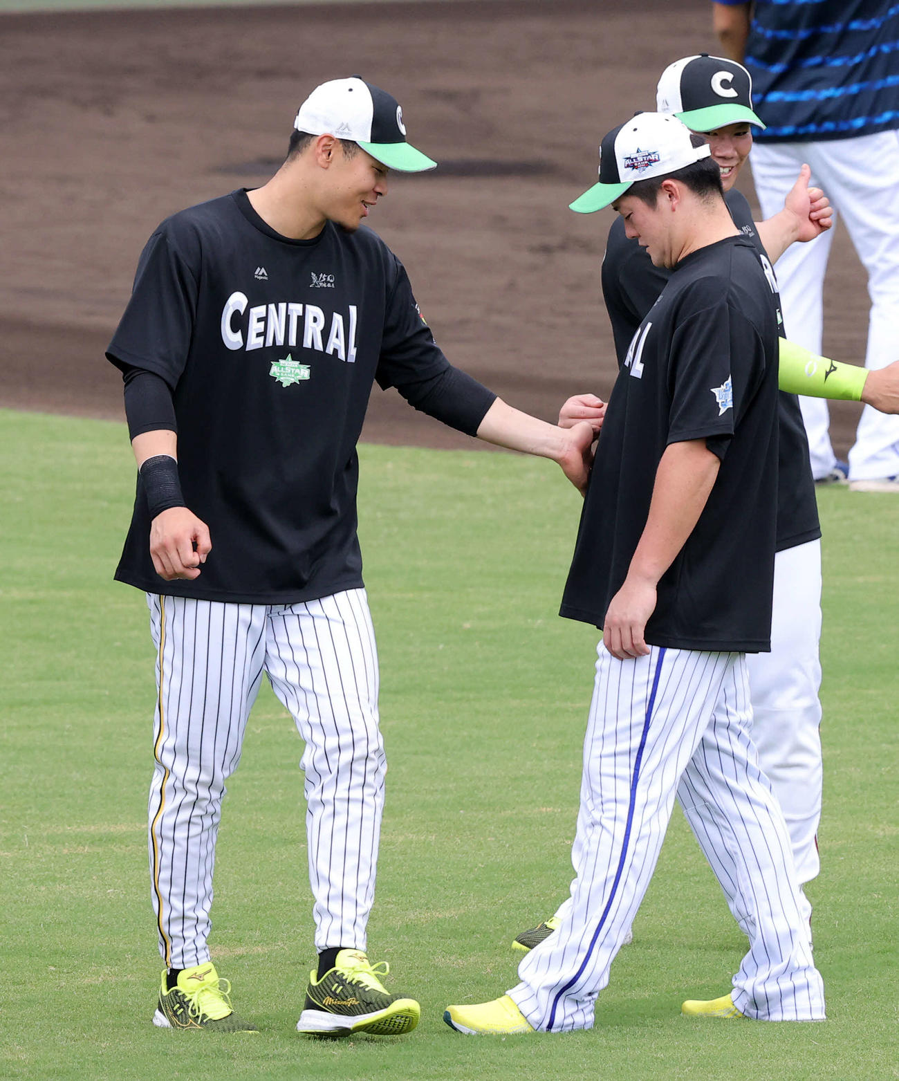 全セ対全パ　試合前練習中、牧（右）のお腹をさわる佐藤輝（撮影・浅見桂子）