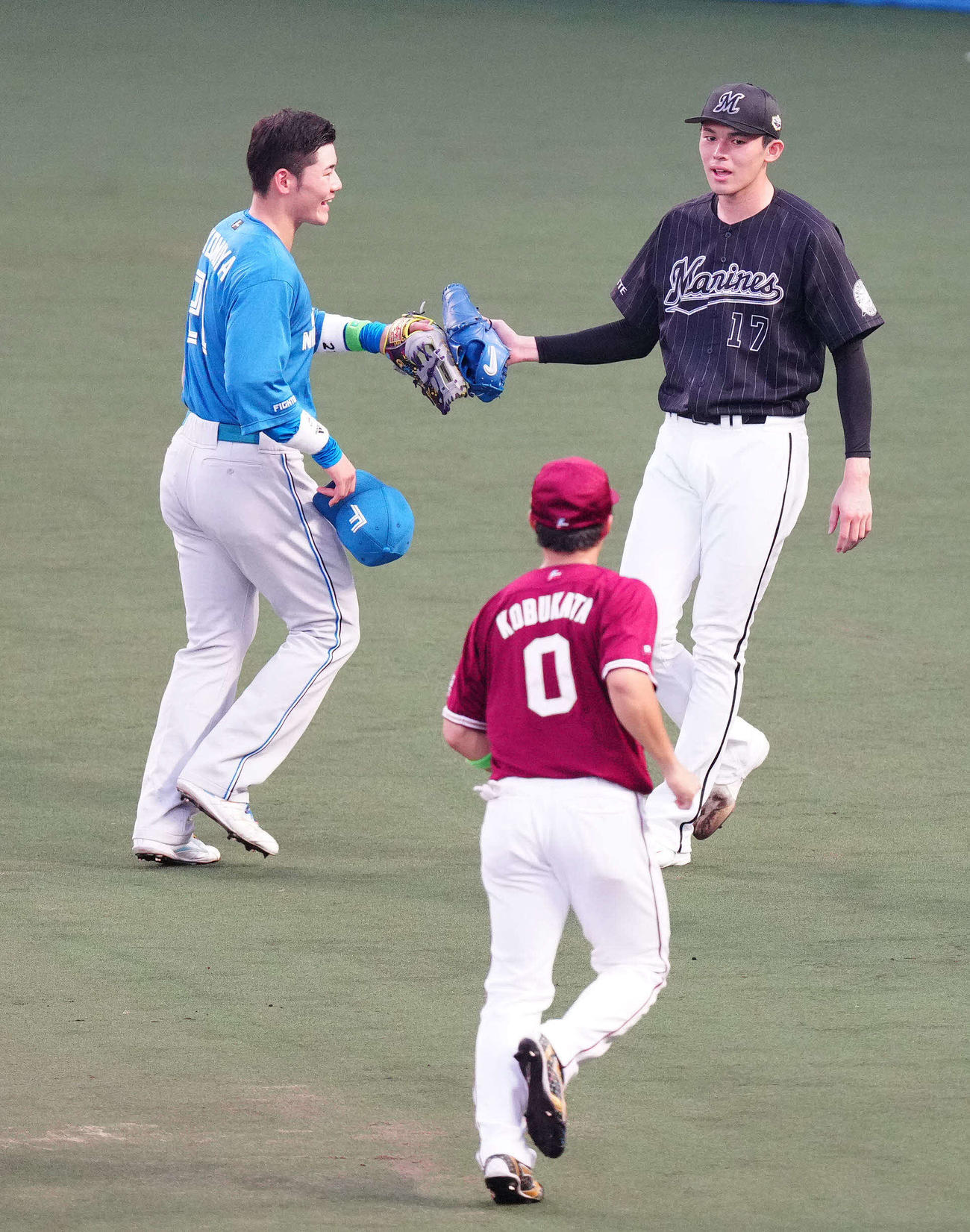 全セ対全パ　1回裏終了後、全パの清宮（左）とタッチを交わしながらベンチに引き揚げる先発の佐々木朗（撮影・江口和貴）