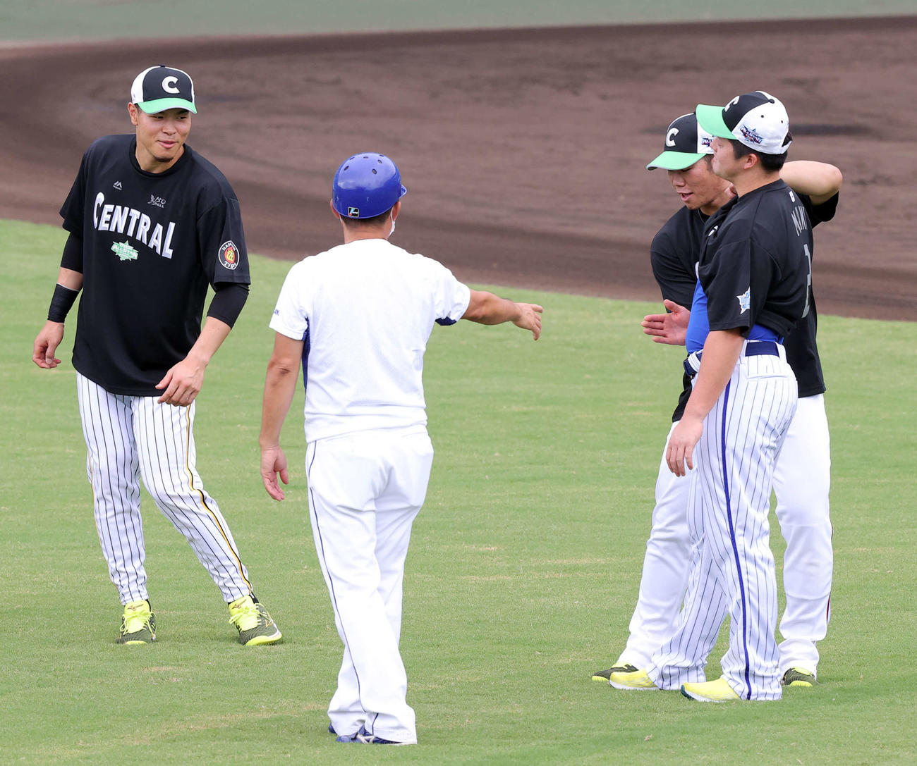 全セ対全パ　試合前練習中、牧（右）のお腹を叩く坂倉（右奥）を見て笑顔の佐藤輝（撮影・浅見桂子）