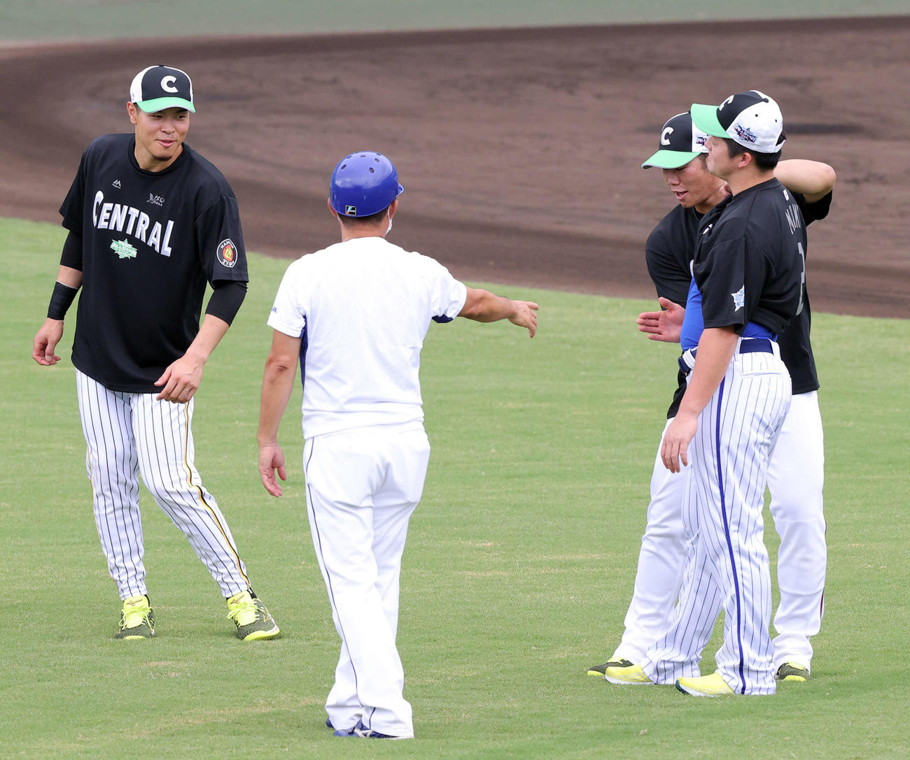 全セ対全パ　試合前練習中、牧（右）のお腹を叩く坂倉（右奥）を見て笑顔の佐藤輝（撮影・浅見桂子）