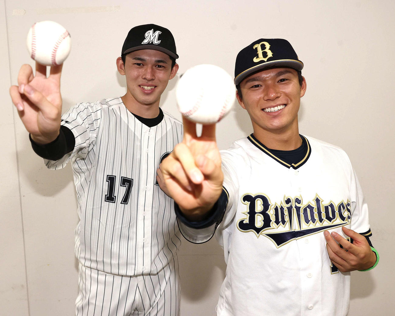 笑顔を見せながらリリースポーズを決めるロッテ佐々木朗（左）とオリックス山本（撮影・上田博志）