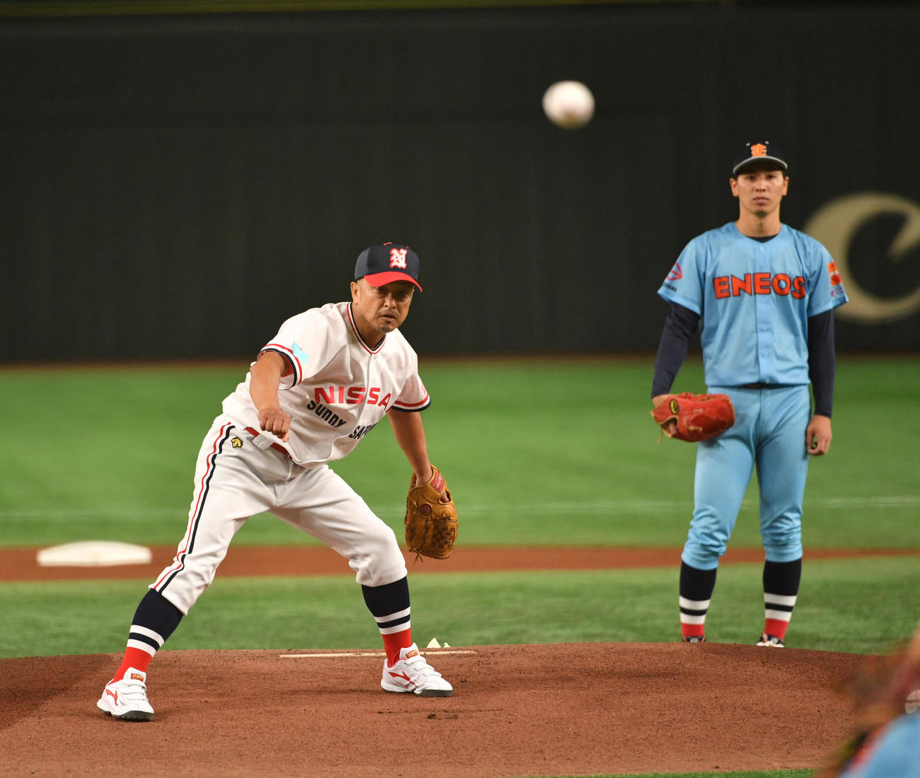 NTT東日本対ENEOSの試合で、始球式を務めた佐藤公治氏。右はENEOS・加藤三範投手（撮影・柴田隆二）