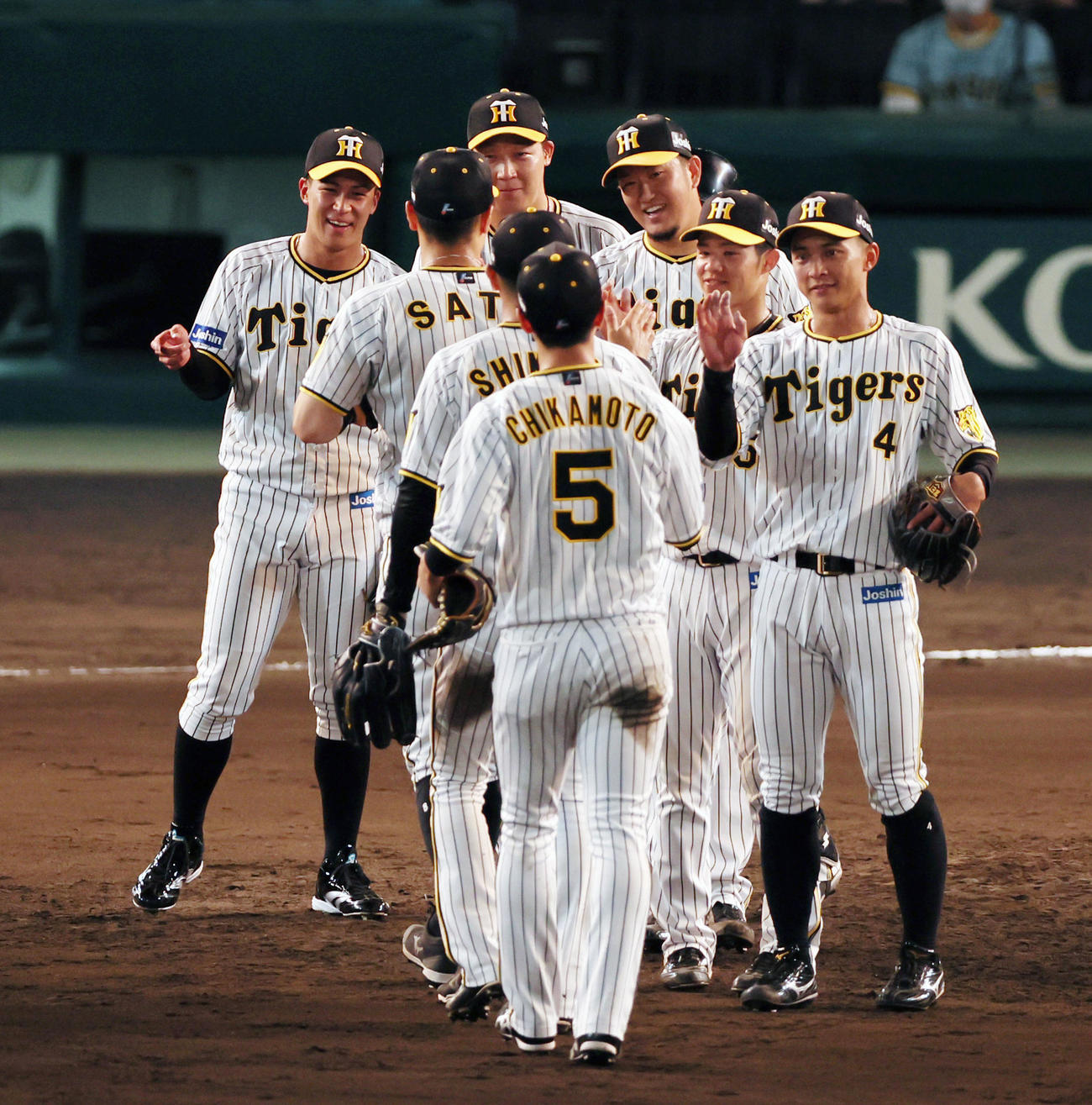 阪神対ヤクルト　9回に登板し無失点ピッチングで締めた岩貞（中央右）は笑顔でナインとタッチする（撮影・加藤哉）