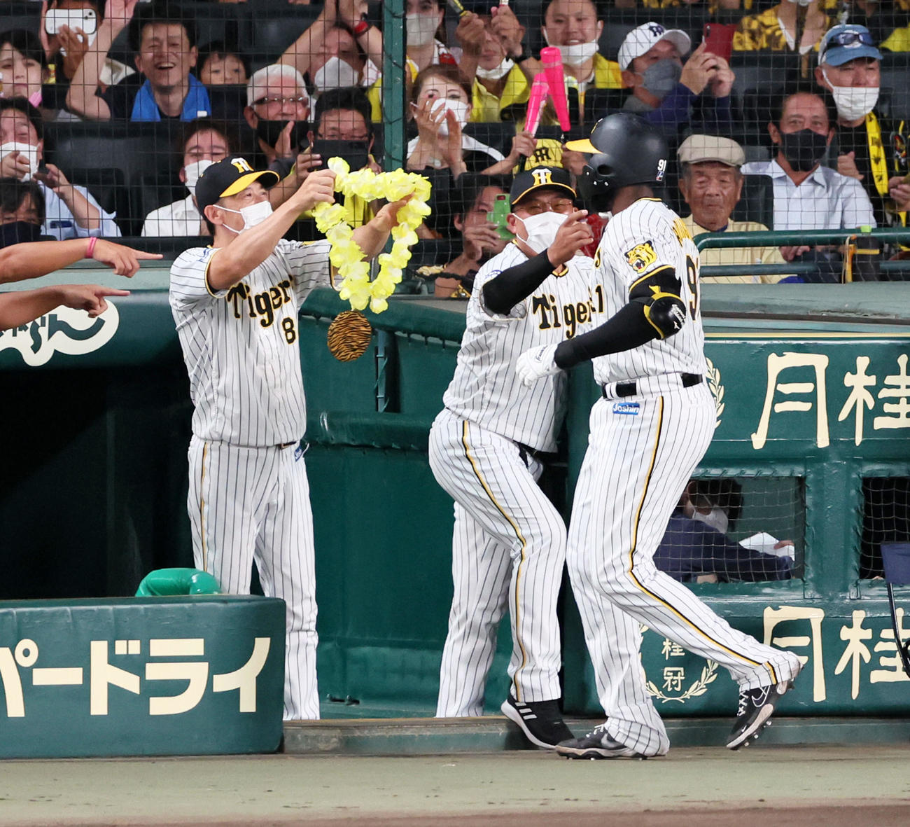 阪神対ヤクルト　4回裏阪神無死、左越えソロ本塁打を放ったロドリゲス（右）にメダルをかける矢野監督（撮影・加藤哉）