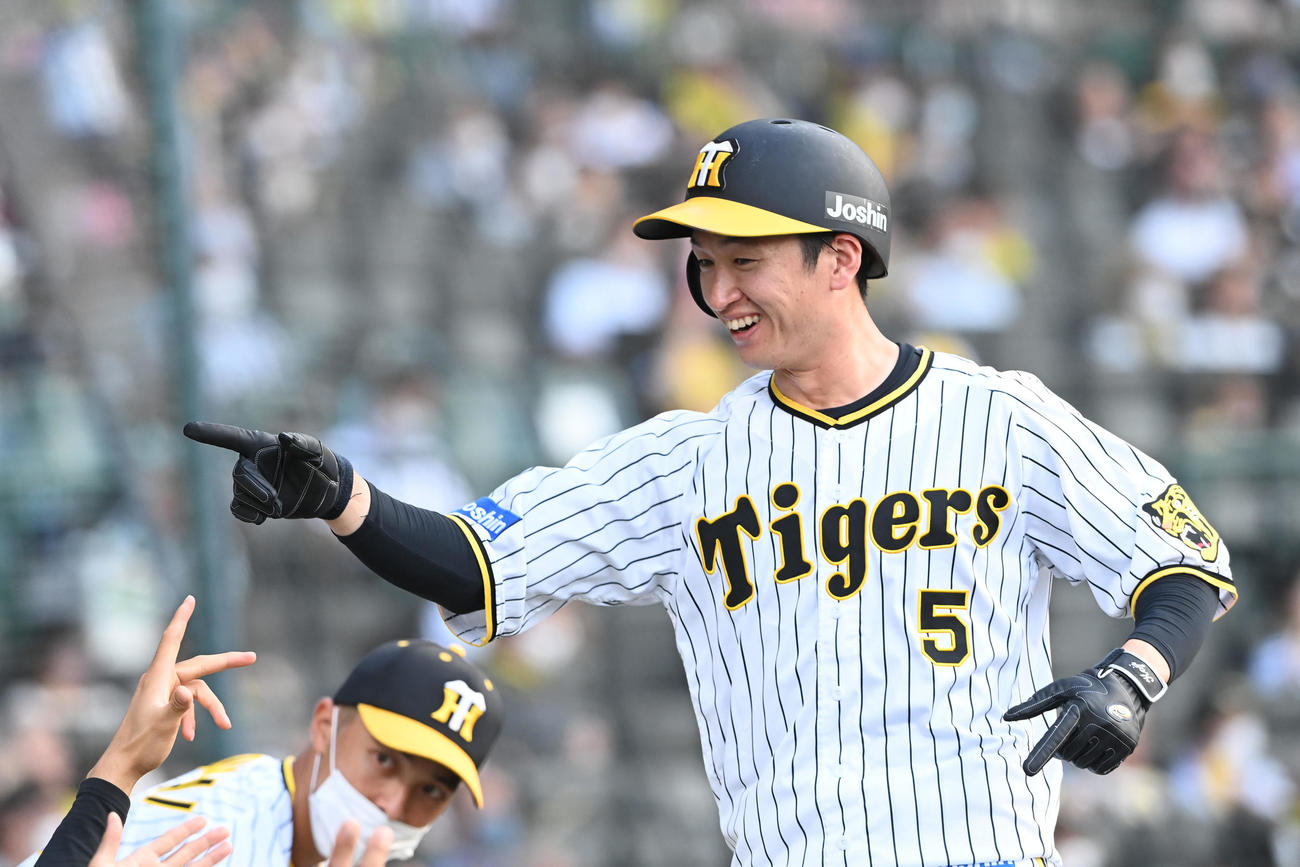 阪神対ヤクルト　1回裏阪神1死一、三塁、糸原の投ゴロで生還した近本はナインの祝福に笑顔を見せる（撮影・前岡正明）