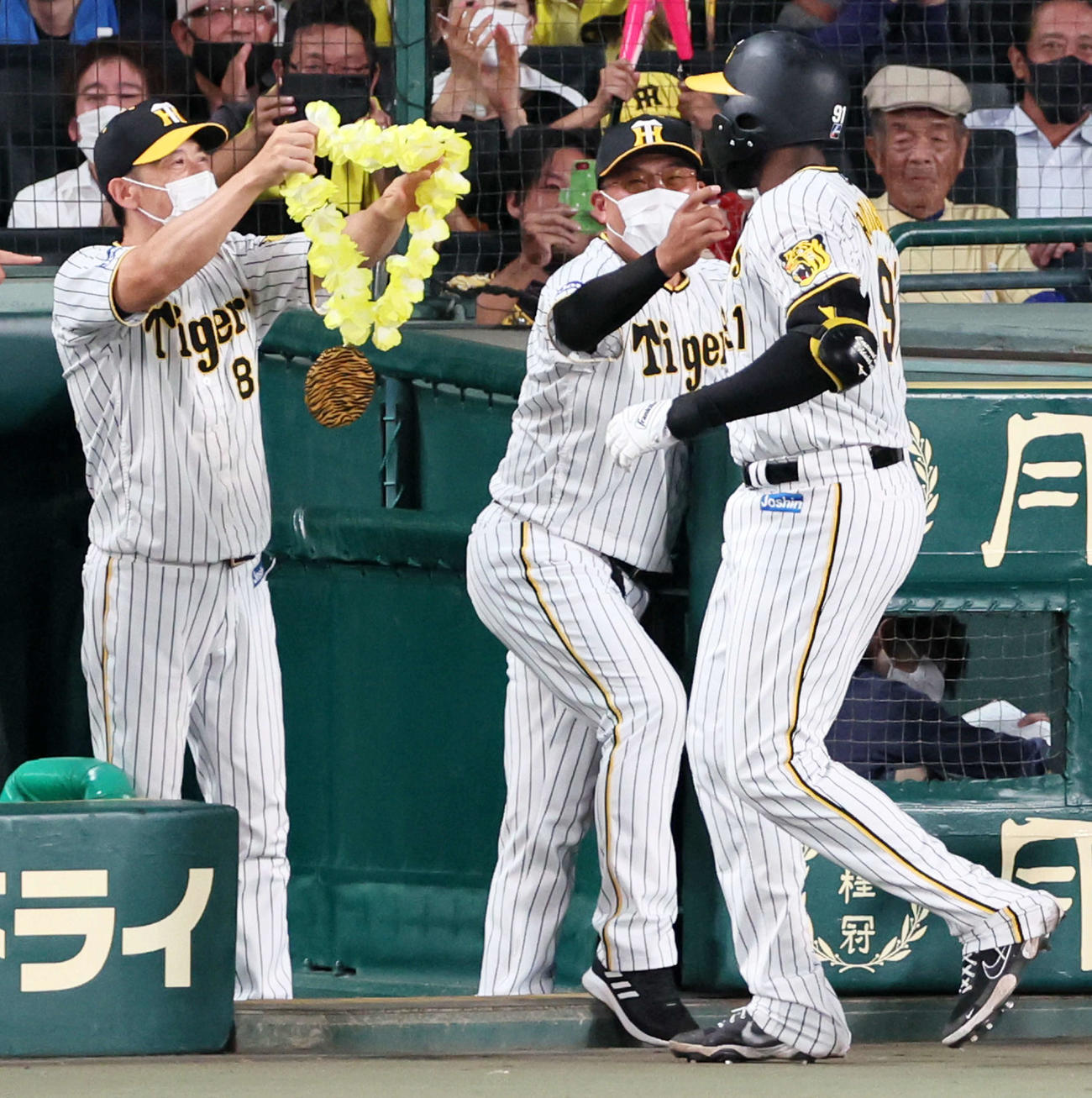 阪神対ヤクルト　4回裏阪神無死、左越えソロ本塁打を放ったロドリゲス（右）にメダルをかける矢野監督（左）（撮影・加藤哉）