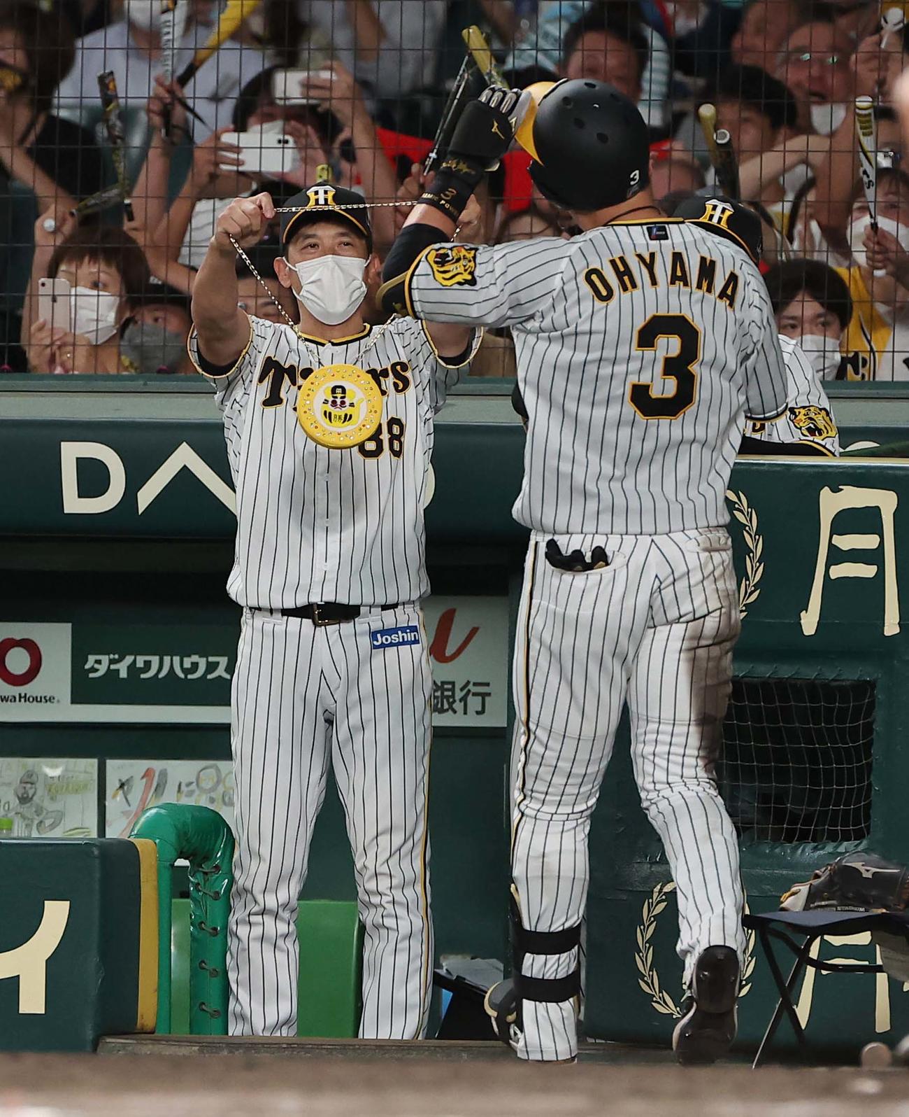 阪神対ヤクルト　8回裏阪神無死、矢野監督（左）は左越えソロ本塁打を放った大山を本塁打メダルを持って出迎える（撮影・上田博志）