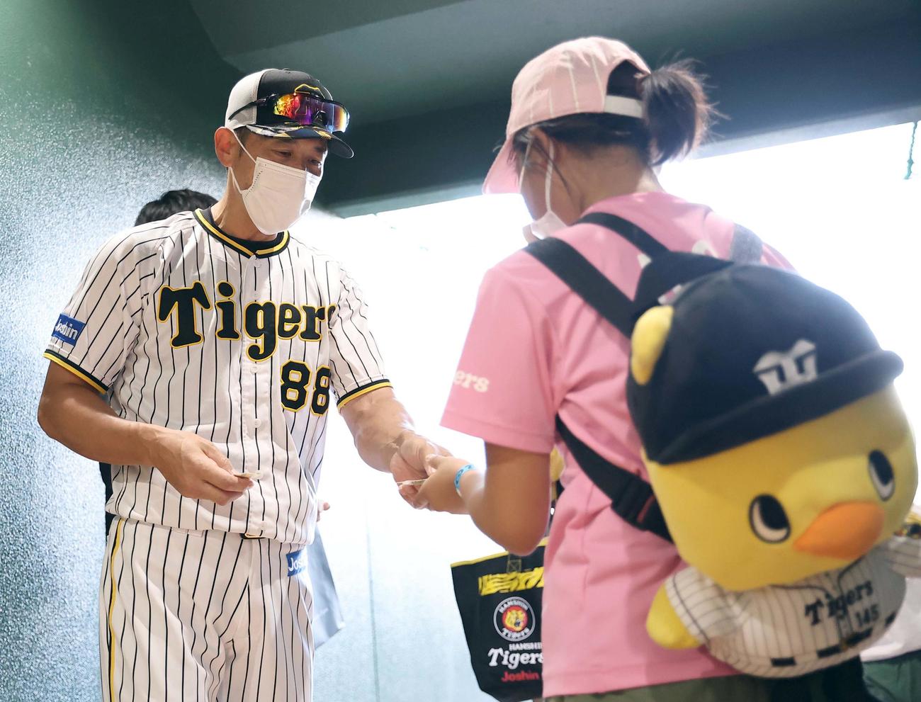 阪神対ヤクルト　訪れた子供ファンにスローガンステッカーを手渡す矢野監督（撮影・上田博志）