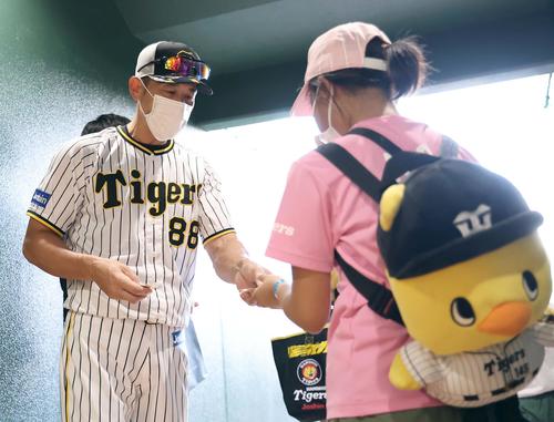 阪神対ヤクルト　訪れた子供ファンにスローガンステッカーを手渡す矢野監督（撮影・上田博志）