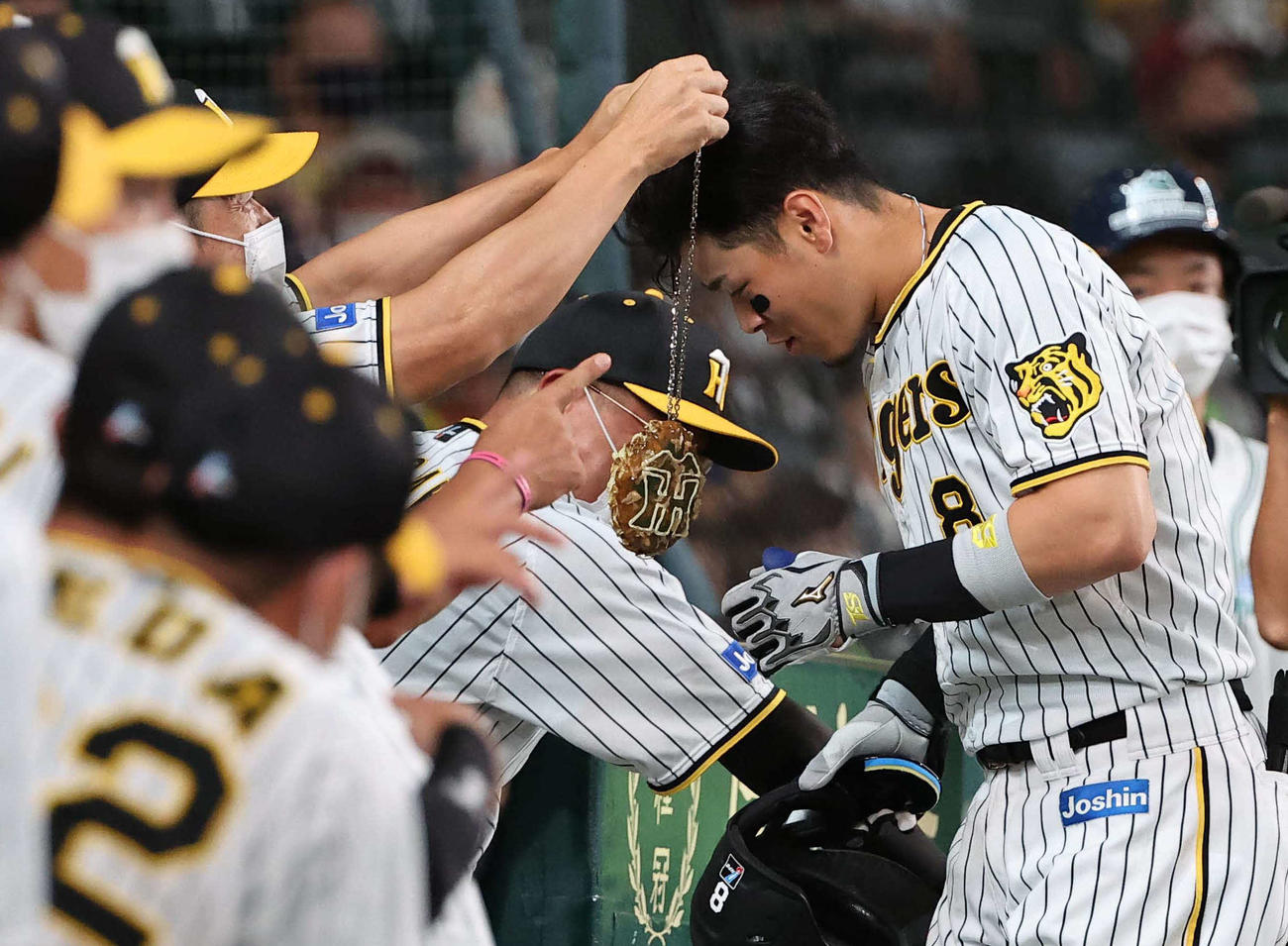 阪神対ヤクルト　5回裏阪神無死、左越えソロ本塁打を放った佐藤輝は、矢野監督にお好み焼き状のメダルをかけてもらう（撮影・上田博志）