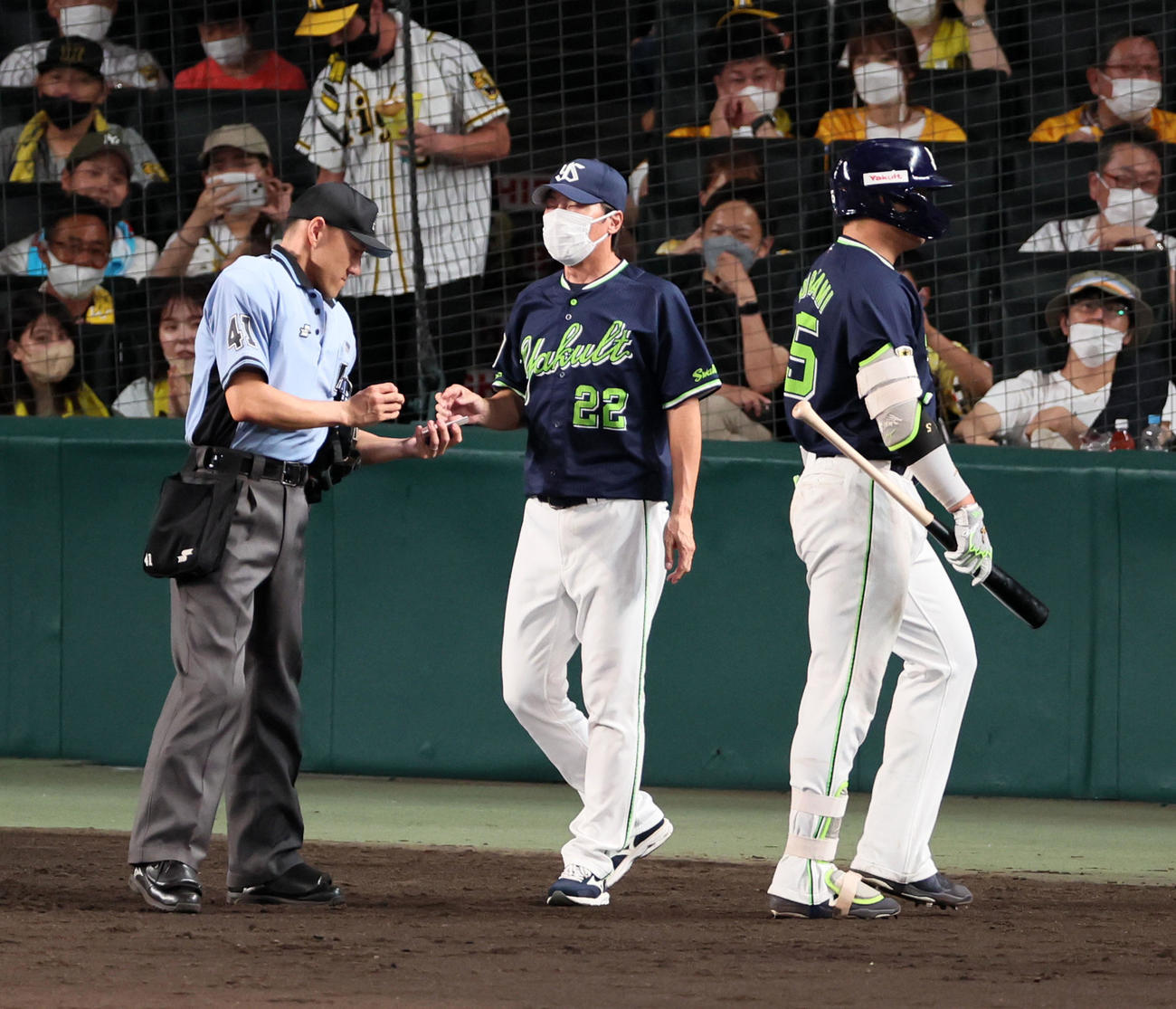 阪神対ヤクルト　8回表を終え選手交代を告げる高津監督。右は三振しベンチへ引き揚げる村上（撮影・加藤哉）