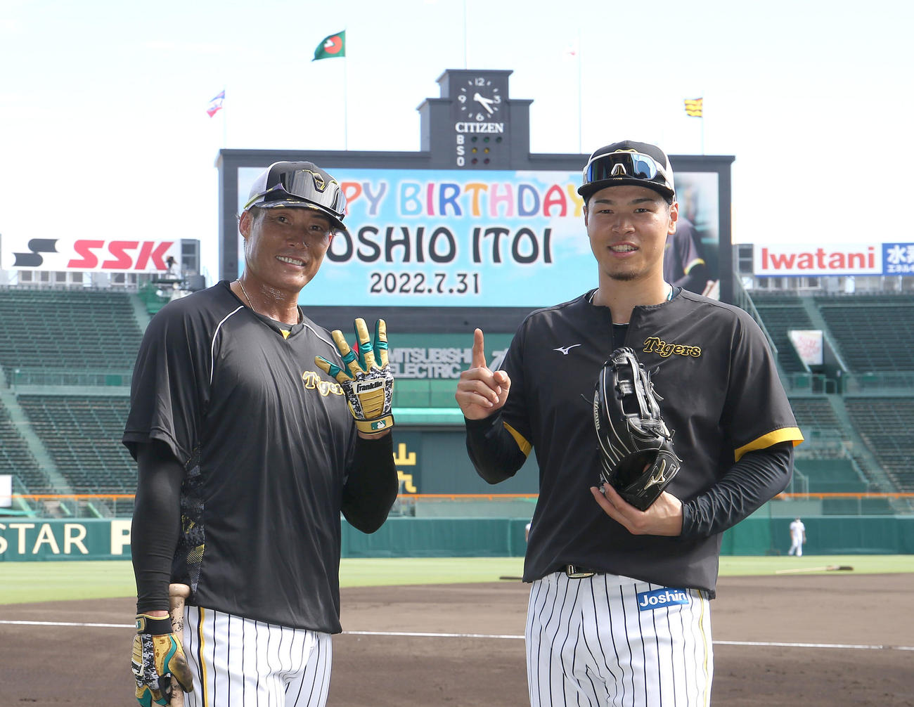 阪神対ヤクルト　HAPPYBIRTHDAY YOSHIO ITOIと表示されたビジョンをバックにポーズをとる糸井（左）と佐藤輝（撮影・白石智彦）