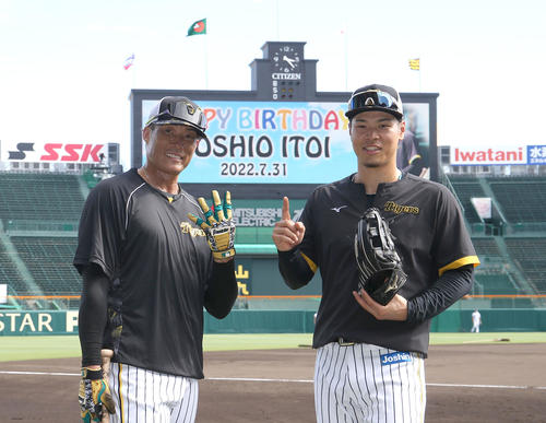 阪神対ヤクルト　HAPPYBIRTHDAY YOSHIO ITOIと表示されたビジョンをバックにポーズをとる糸井（左）と佐藤輝（撮影・白石智彦）