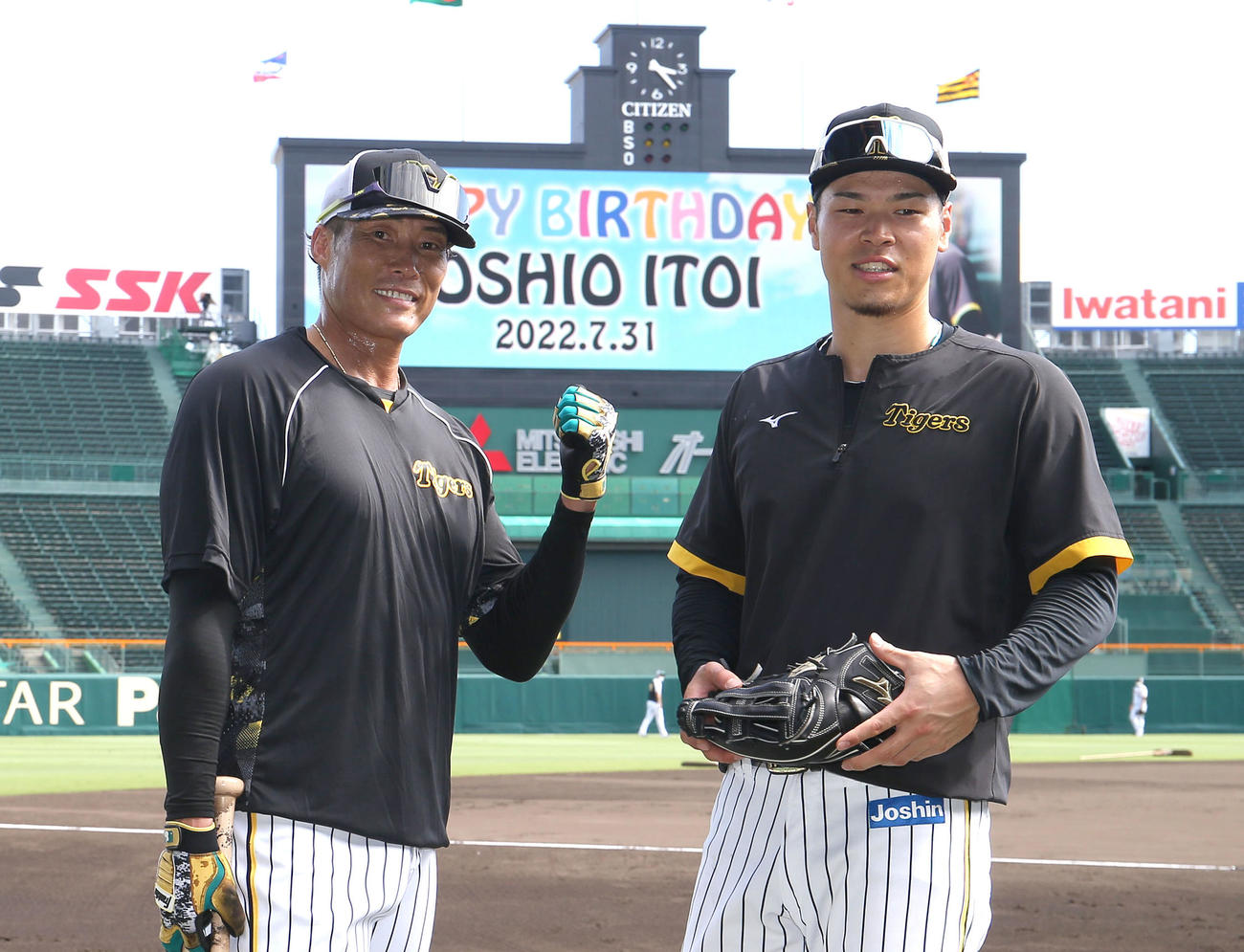 阪神対ヤクルト　HAPPYBIRTHDAY YOSHIO ITOIと表示されたビジョンをバックにポーズをとる糸井（左）と佐藤輝（撮影・白石智彦）