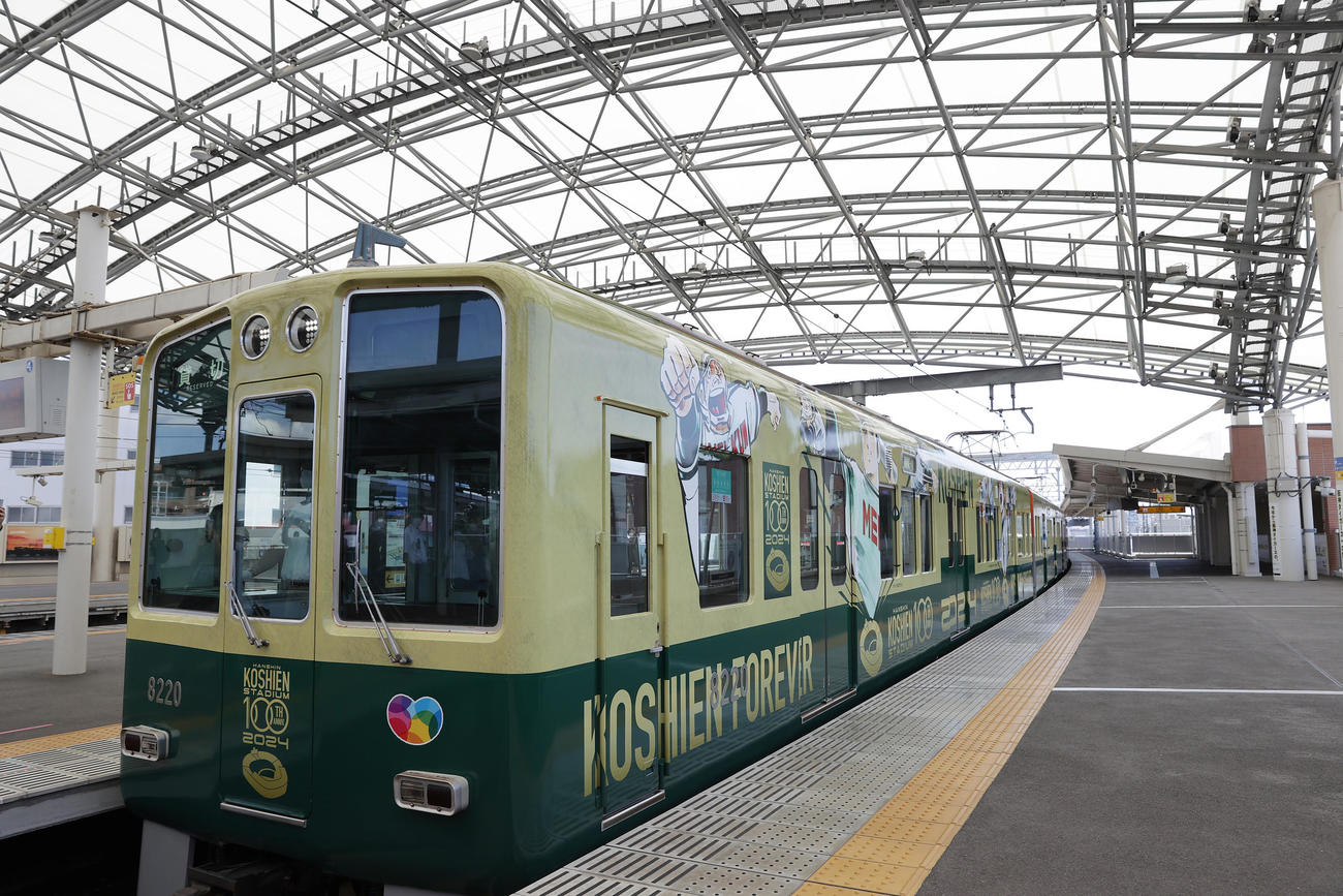 「阪神甲子園球場100周年記念事業・ラッピングトレイン出発式」で甲子園駅のホームに入線する、名作野球マンガがラッピングされた車両（撮影・前田充）