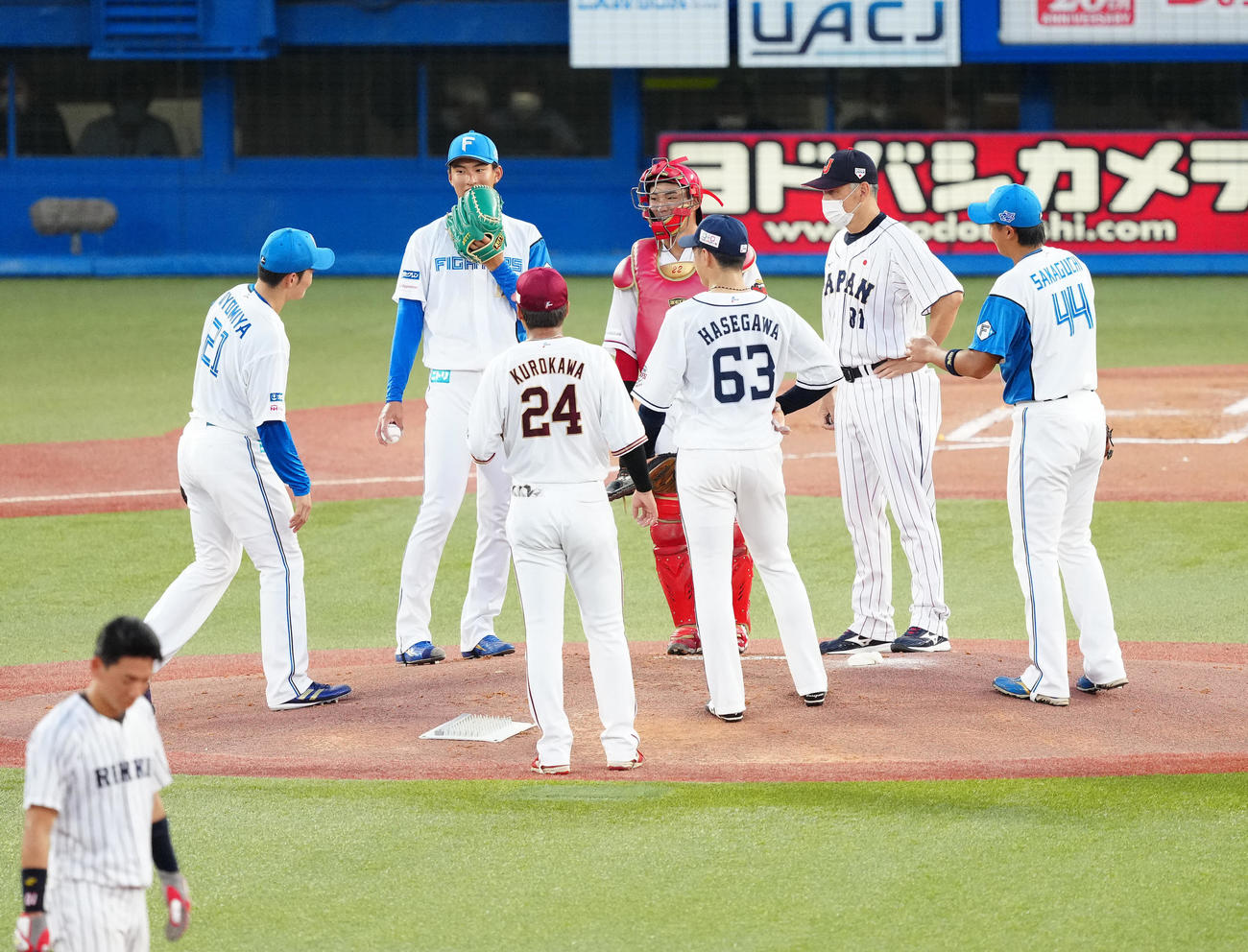 U23NPB選抜対大学・社会人選抜　2回表、マウンドで激励を受けるU23NPB選抜2番手の達（左から2人目）（撮影・江口和貴）