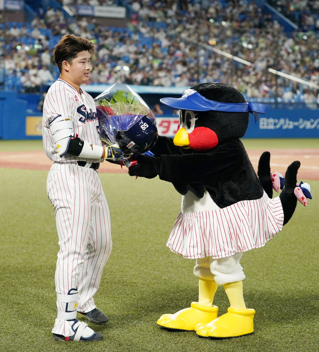 ヤクルト対中日　3回裏ヤクルト1死一塁、プロ野球新記録の5打席連続となる左中間への2点本塁打を放ち、つばみ（右）から花束を受け取る村上（撮影・横山健太）