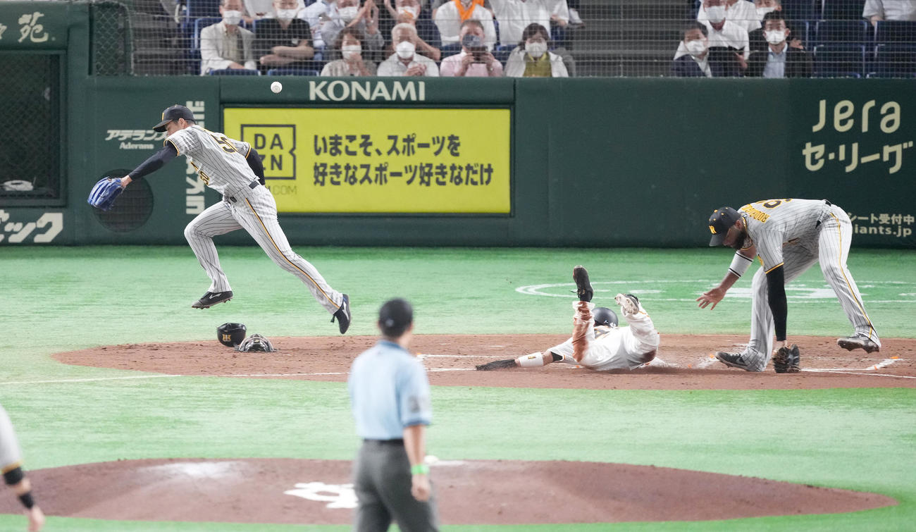 巨人対阪神　4回裏巨人無死一、三塁、大山の送球が本塁にそれ、三塁走者重信の生還を許す。右はロドリゲス、左は青柳（撮影・菅敏）
