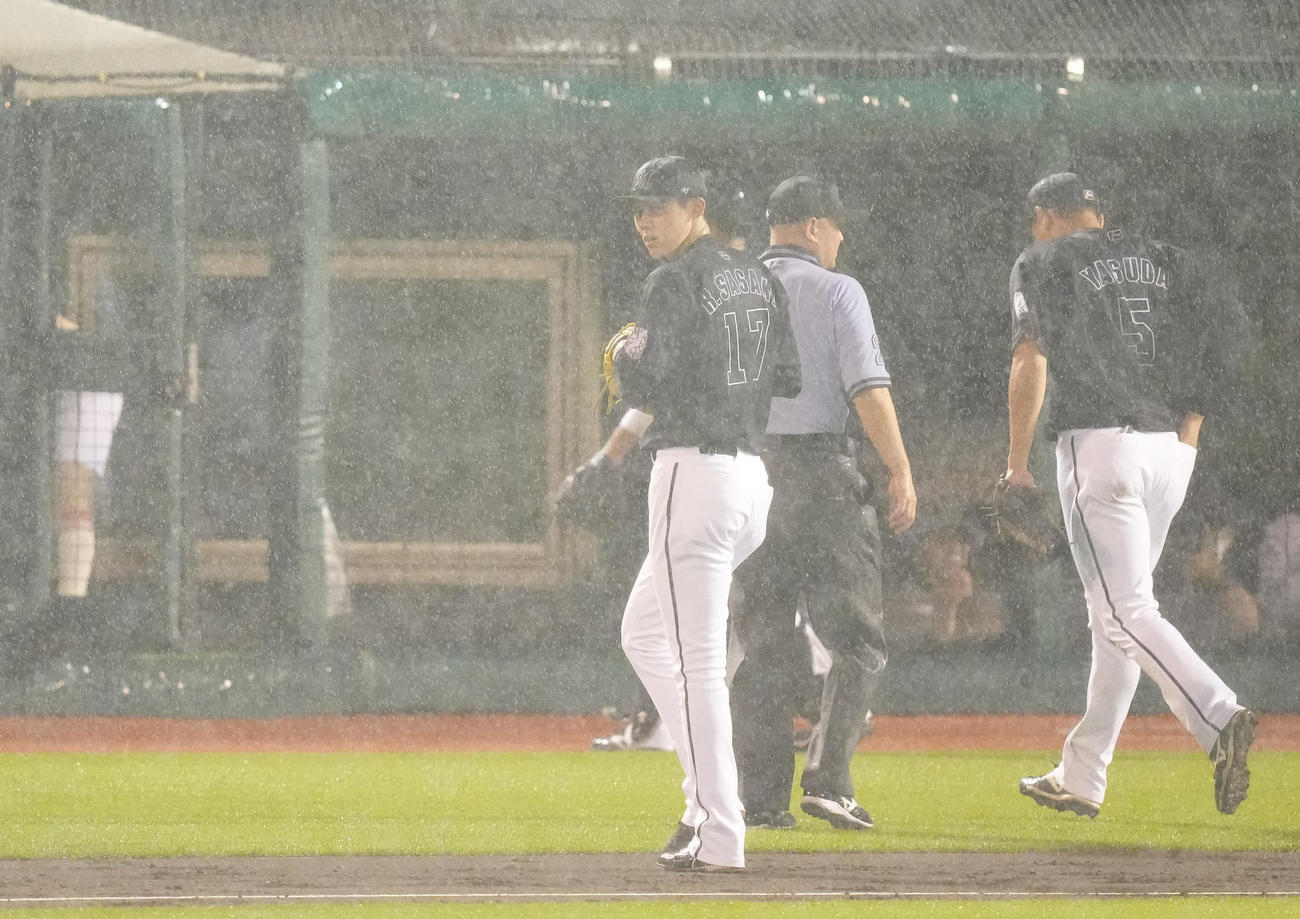 楽天対ロッテ　4回裏楽天無死一塁、雨脚が強くなり試合が中断しベンチへ戻る佐々木朗（撮影・鈴木みどり）