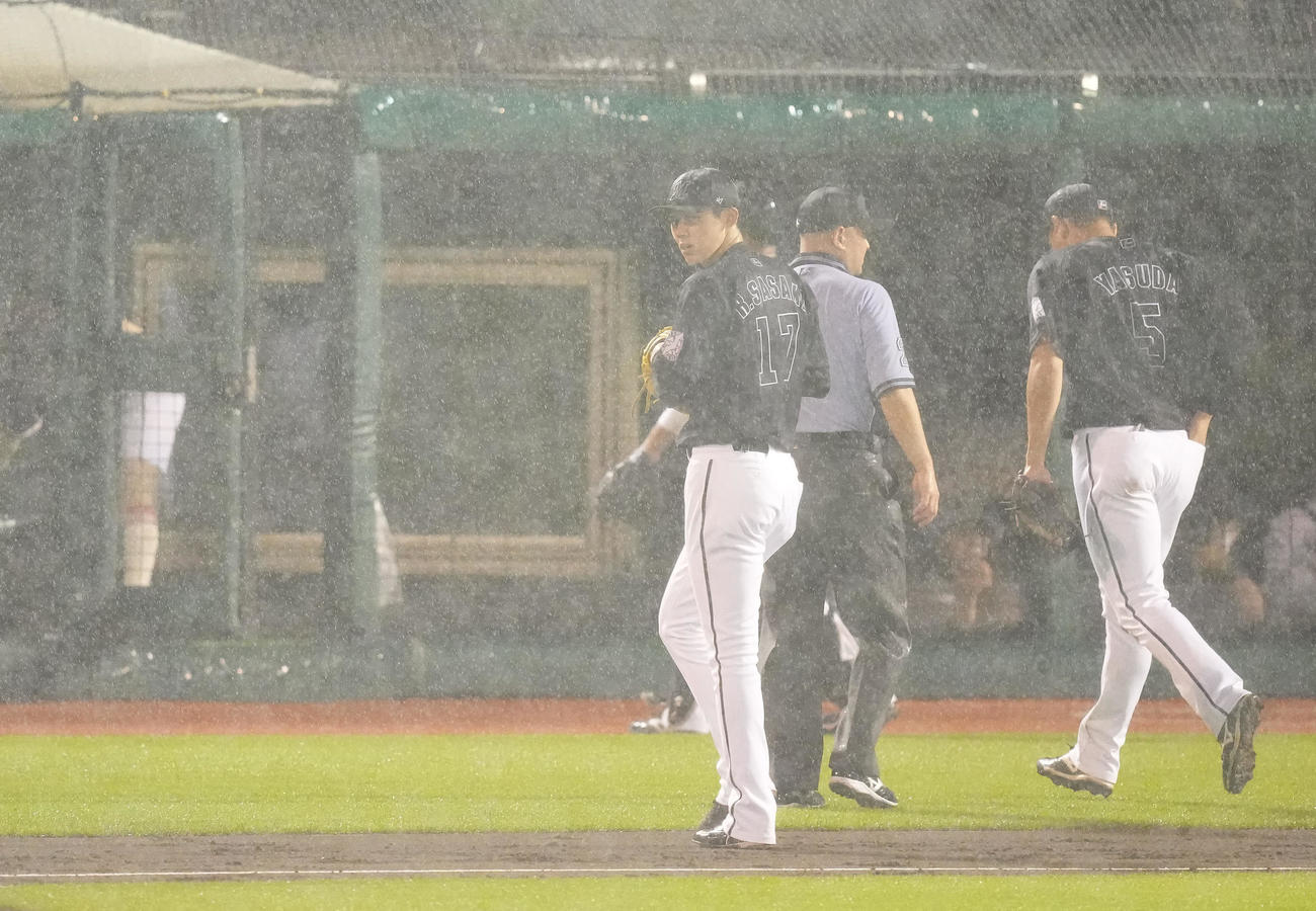 楽天対ロッテ　4回裏楽天無死一塁、雨脚が強くなり試合が中断しベンチへ戻る佐々木朗（撮影・鈴木みどり）
