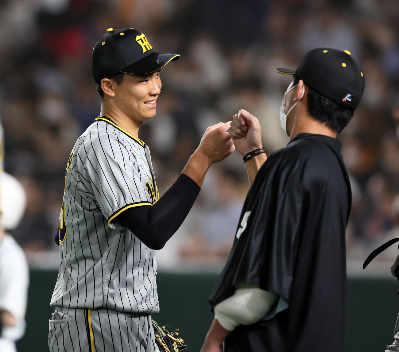 巨人対阪神　8回裏、阪神3番手で登板した湯浅はベンチ前で伊藤将（右）と笑顔でタッチする（撮影・加藤哉）