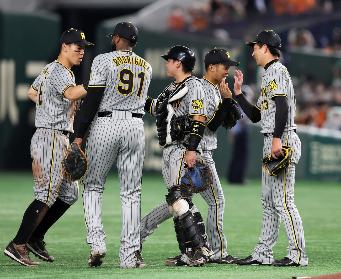 巨人対阪神　巨人に連勝し笑顔でナインとタッチする岩崎（右端）（撮影・加藤哉）