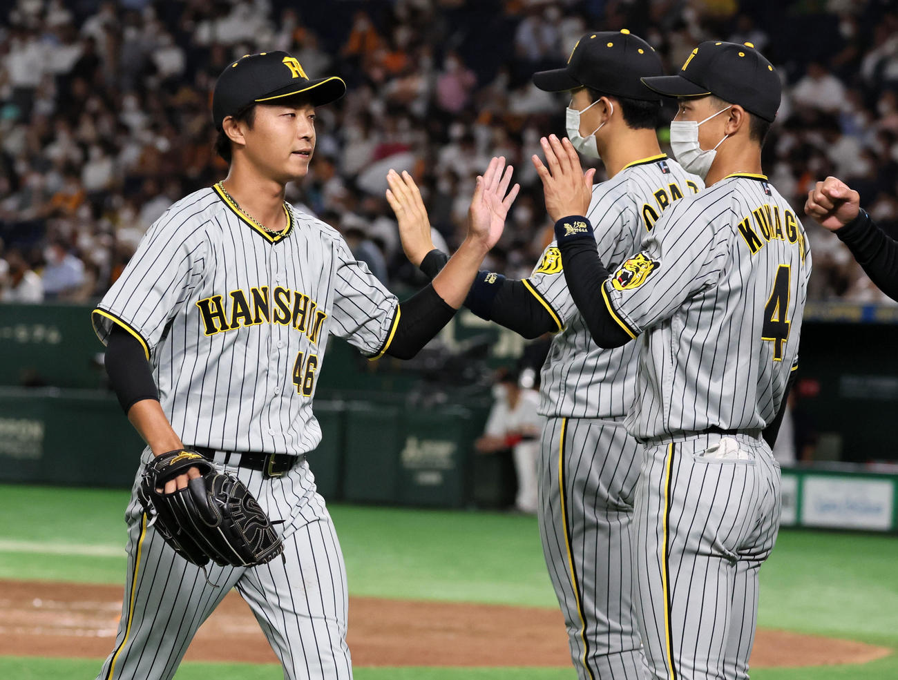 巨人対阪神　6回裏、阪神4番手で登板した島本は無失点ピッチングを披露しナインとタッチする（撮影・加藤哉）