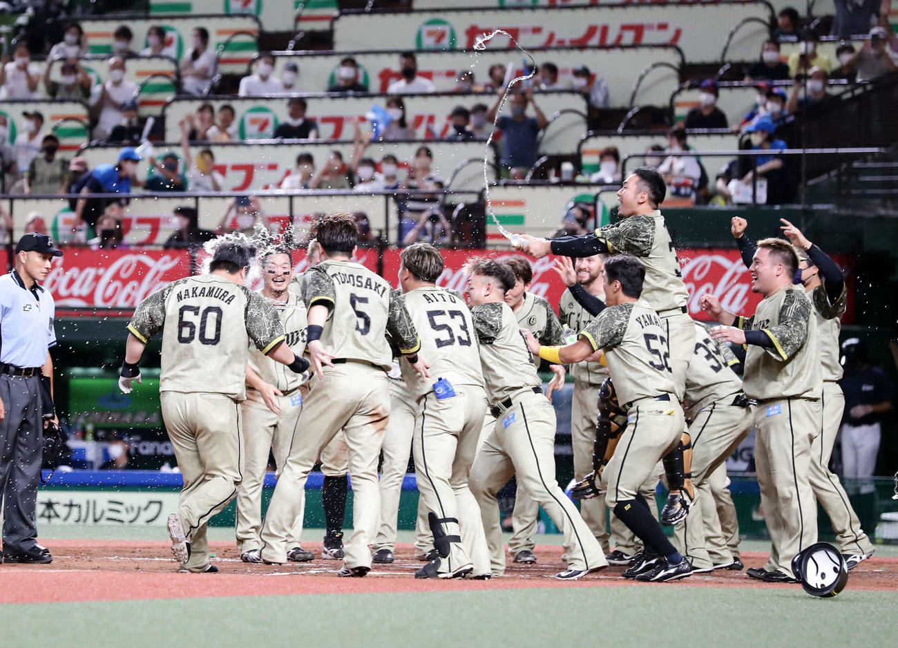 西武対オリックス　9回裏西武1死、中村（左）はサヨナラ本塁打を放ち、水シャワーの祝福を受ける（撮影・浅見桂子）